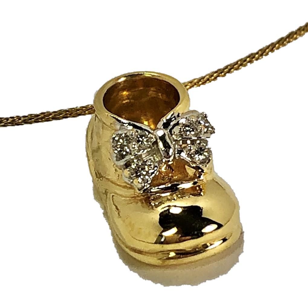 A vintage 18K yellow gold baby shoe pendant with diamonds, hanging delightfully from an 18K yellow gold cable. The pendant measures 7/8 of an inch long, and 7/16 of an inch wide, and the necklace measures 15 inches long. A great gift idea for the