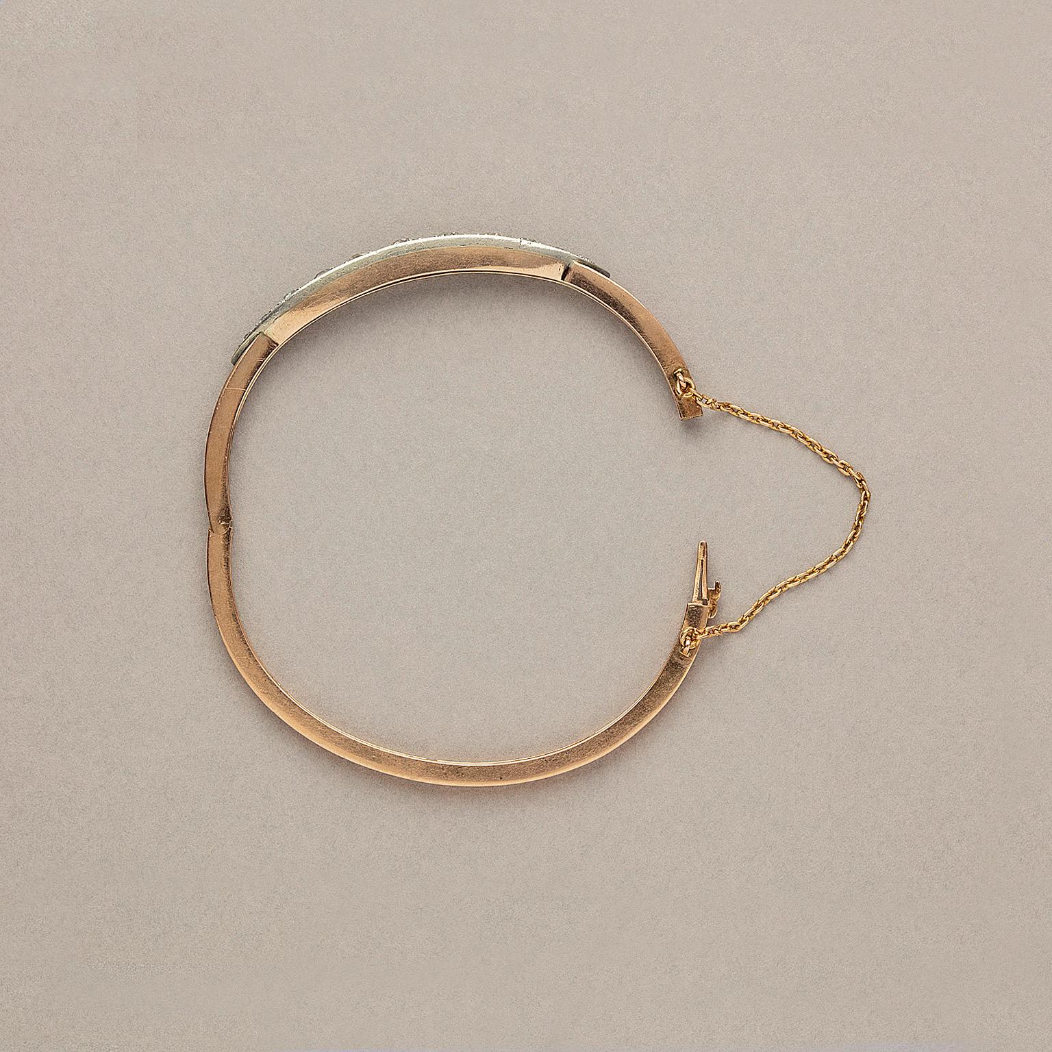 A 14 or 15 karat pink gold bangle with a double band with in between 11 old-cut diamonds (app. 3 carats H SI) graduating in size from the centre in a navette shaped silver mounting. Marked ET. Most likely English, circa 1890.
weight: 12.95