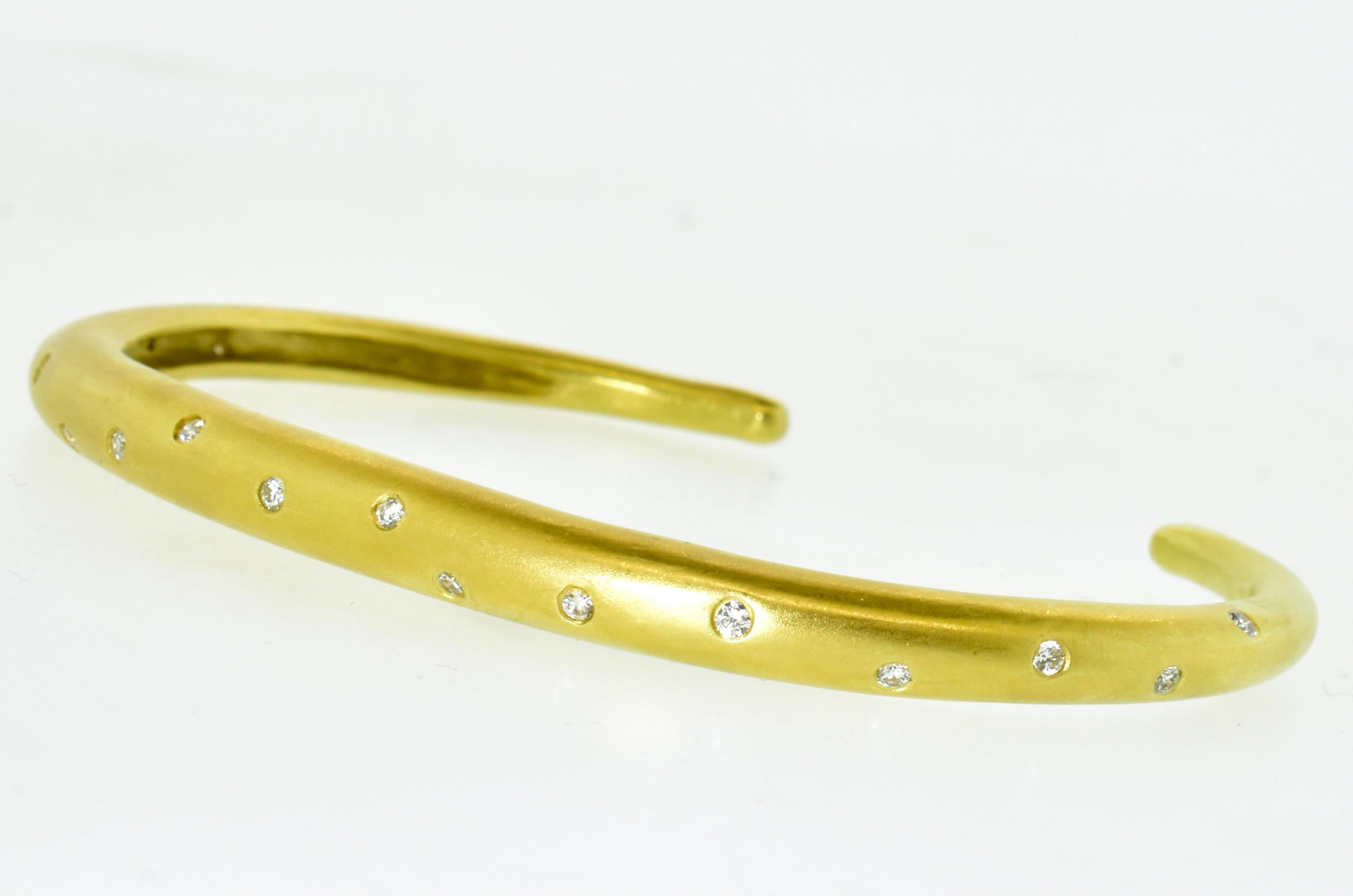 18K gold and diamond studded 3/4 solid bangle. This fine bracelet is not to be confused with a high weight piece made in a factory in a third world country, This is a hand made bangle is 5.0 to 2.5 mm which weighs 21.45 grams.  It possesses 17 round