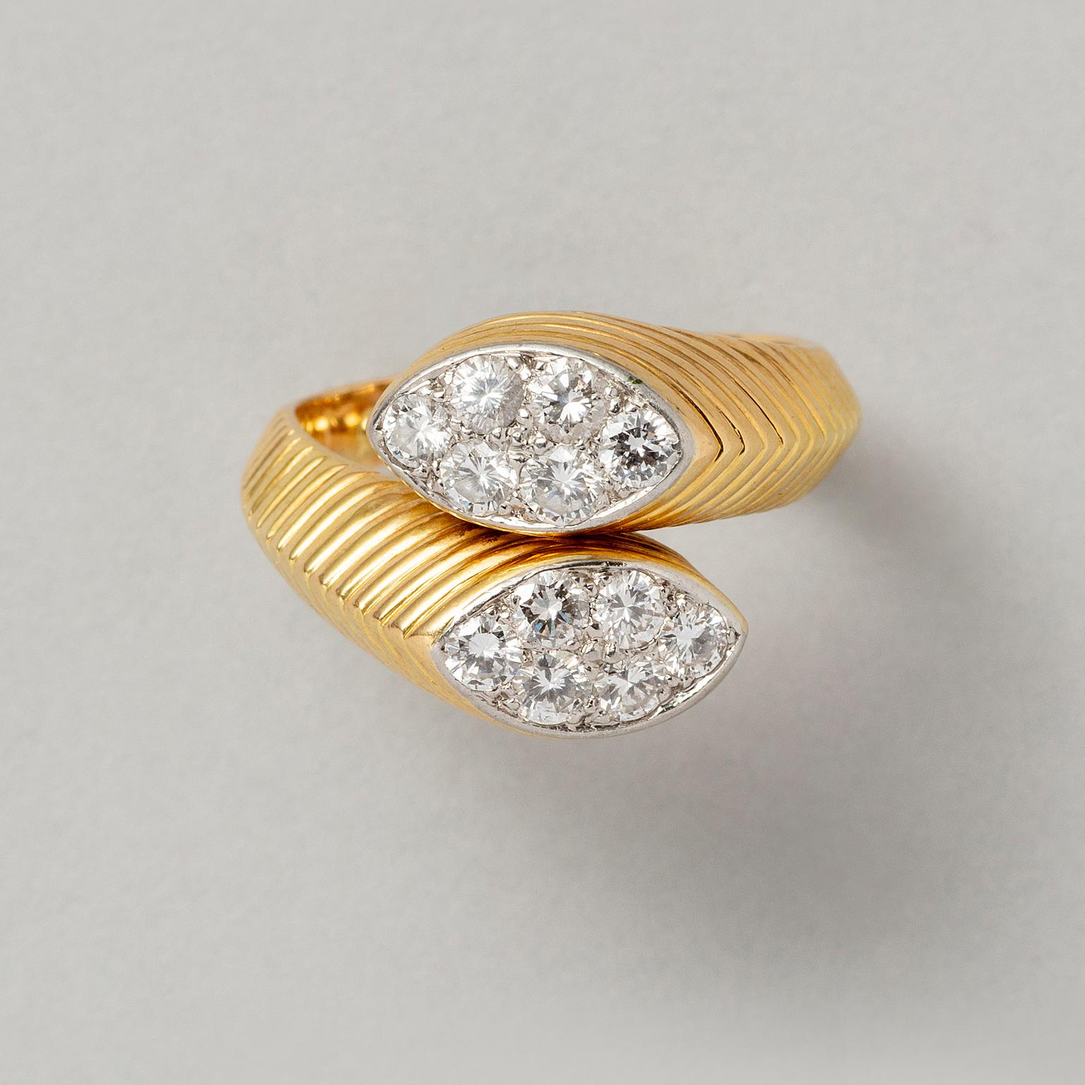 Anello by-pass in oro 18 carati con due elementi a forma di navette con 12 diamanti taglio brillante incastonati, con gambo scanalato, firmato: Cartier gli altri marchi e la numerazione sono scomparsi a causa delle dimensioni, Francia.

peso: 10,2