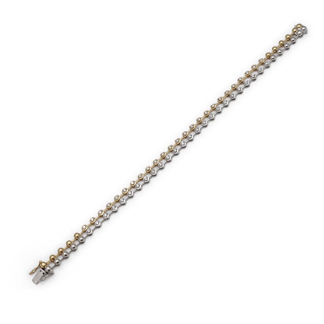 A charming line bracelet crafted in 18 karat yellow and white gold. Two rows of round links are set with round brilliant cut diamonds weighing an estimated .85 carats total. The bracelet measures 7 inches in length with a hidden box clasp. Stamped