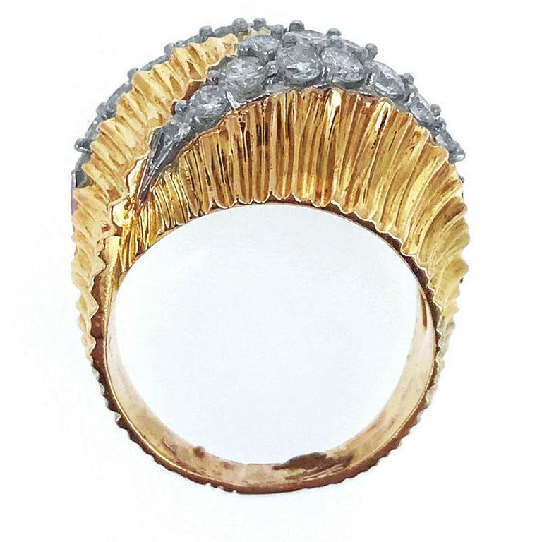 This 18 karat yellow gold textured and fluted ring is pave-set with diamonds weighing approximately 1.5 carats and mounted in platinum. The ring was made circa 1970.