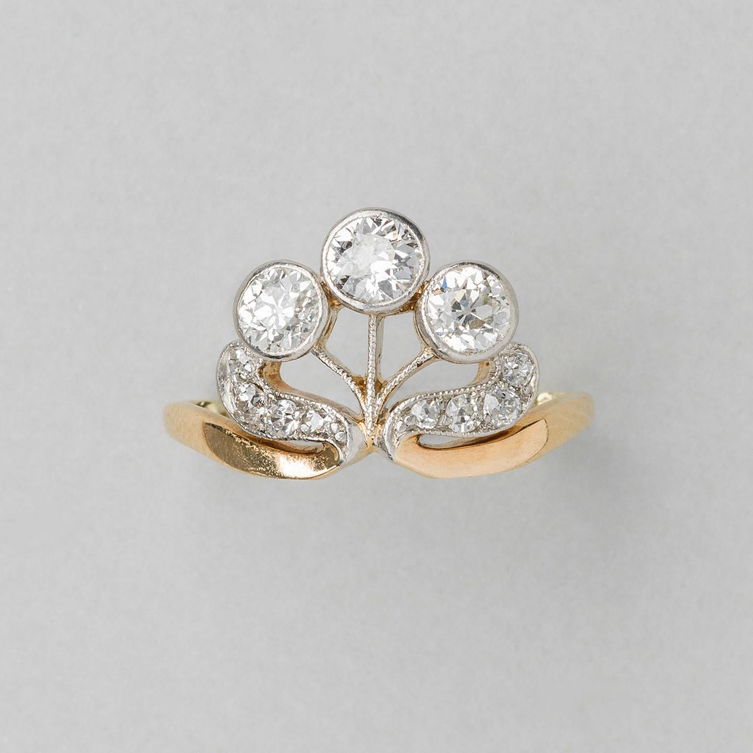 Süßer Ring aus 14 Karat Gelb- und Weißgold mit drei Diamanten auf Goldstielen in Form einer stilisierten Blume in Mille-Griff-Fassung, darunter zwei Goldblätter, besetzt mit kleinen Diamanten im Brillantschliff (insgesamt ca. 1 Karat, H-I, VS-IS),