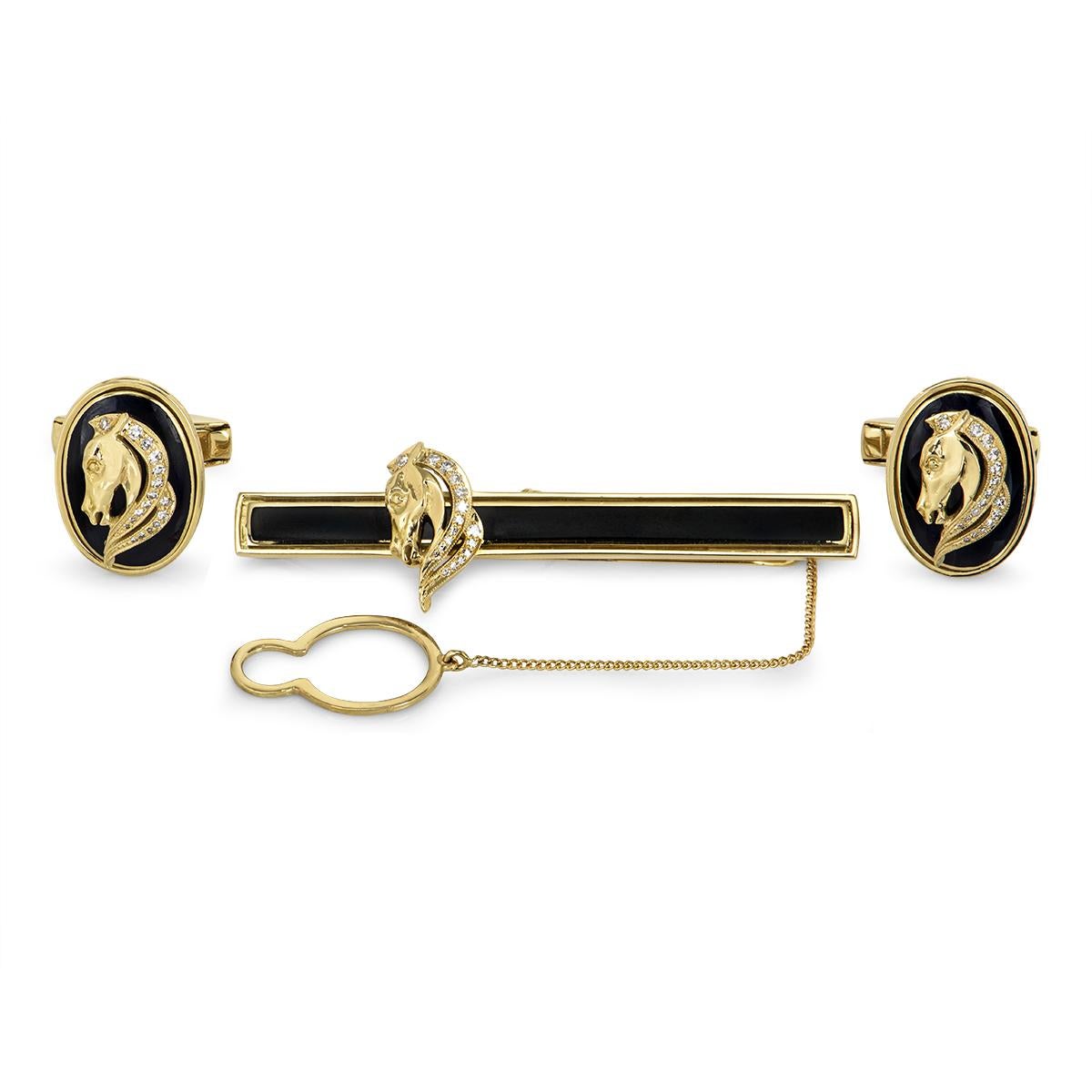 A stunning 18k yellow gold diamond and enamel tie slide and cufflinks set. The 18k yellow gold tie slide is set to the centre with a black enamel inlay featuring a pave set round brilliant cut diamond horse head motif. The tie slide is complemented
