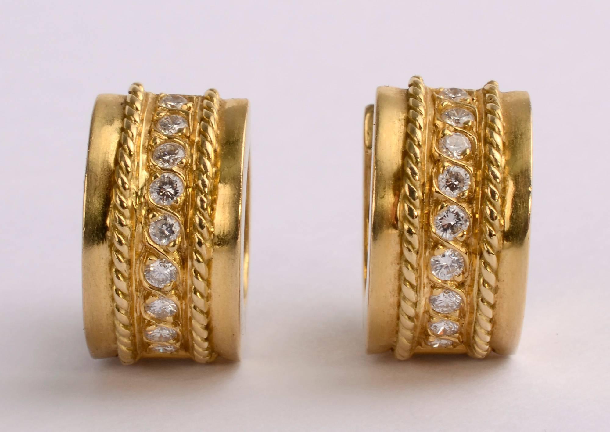 Nicely made huggie hoop earrings with nine diamonds going down the center of each. They are surrounded with a raised, curved gold band that makes for graceful connectivity. The row of diamonds has a raised rope twist band on either side.
Post backs.