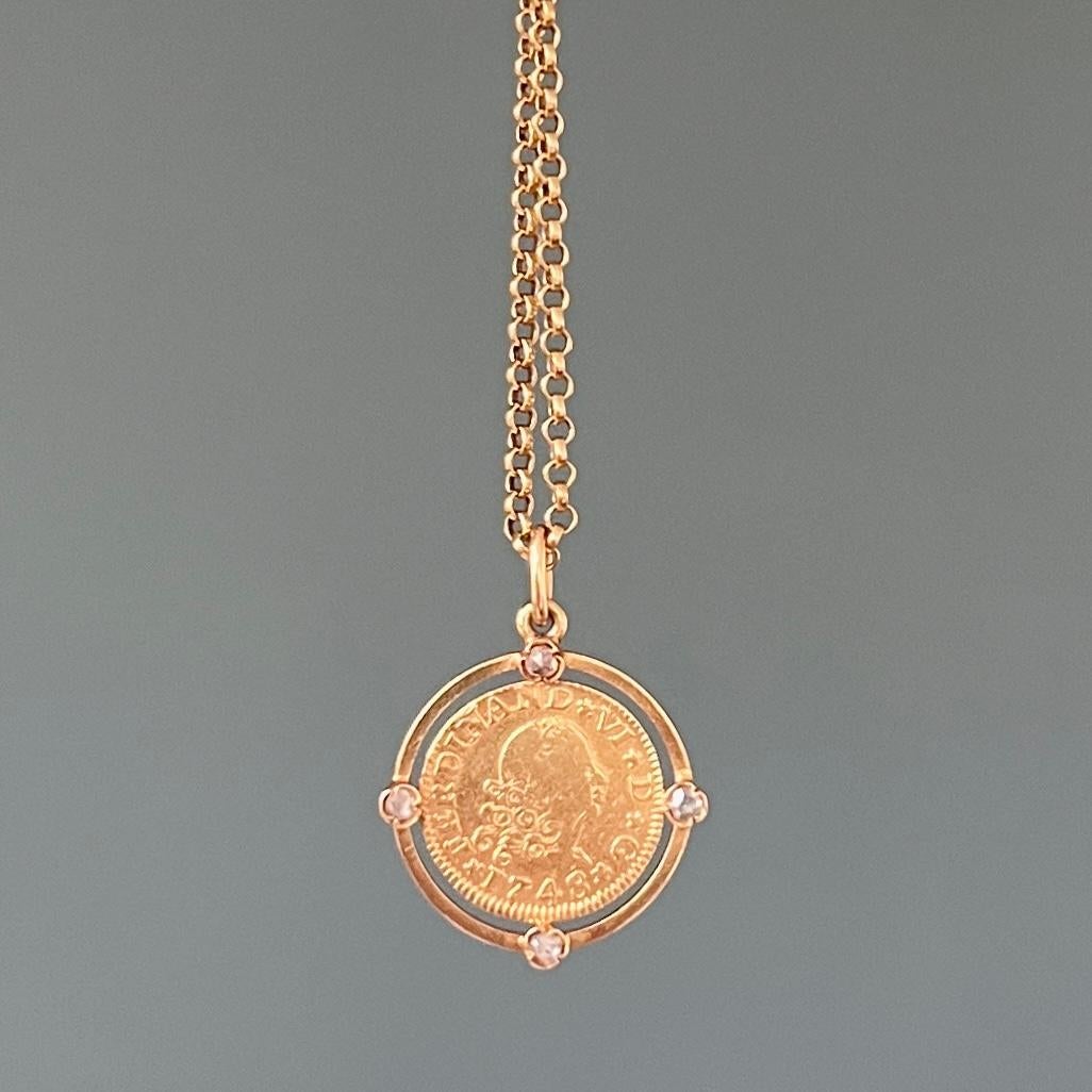 An antique gold ½ Escudo coin of the Spanish King Ferdinand VI from 1748. The pendant is surrounded by a frame pendant of 14 karat gold set with four rose cut diamonds. The diamonds have a diameter Ø of approx. 2.0 mm. The diamond frame is attached