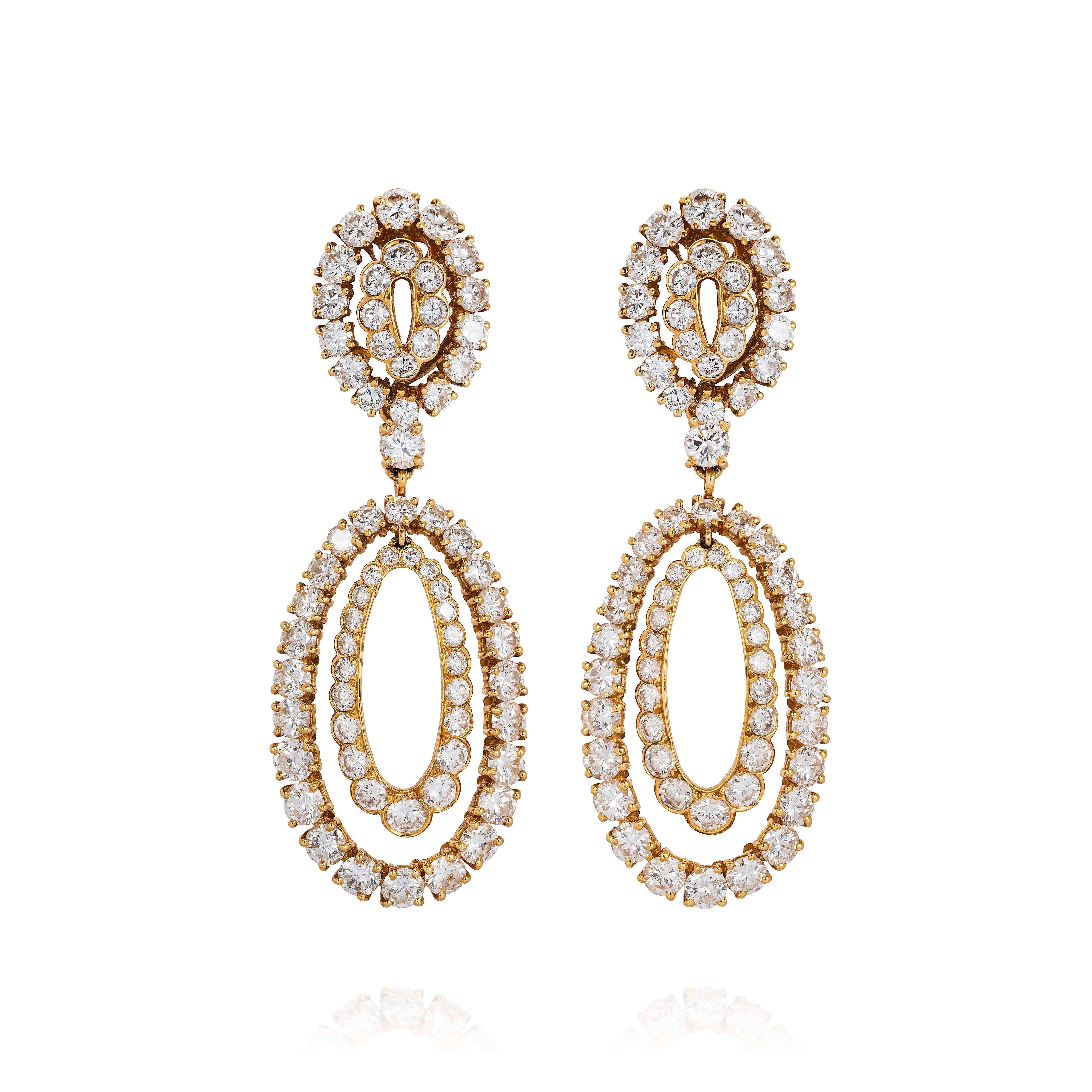 A gold and diamond parure by Van Cleef & Arpels comprised of a detachable brooch/pendant and chain arranged in oval festoons, and a pair of night and day earrings of the same design. In 18KT yellow gold, set with approximately 60cts of round