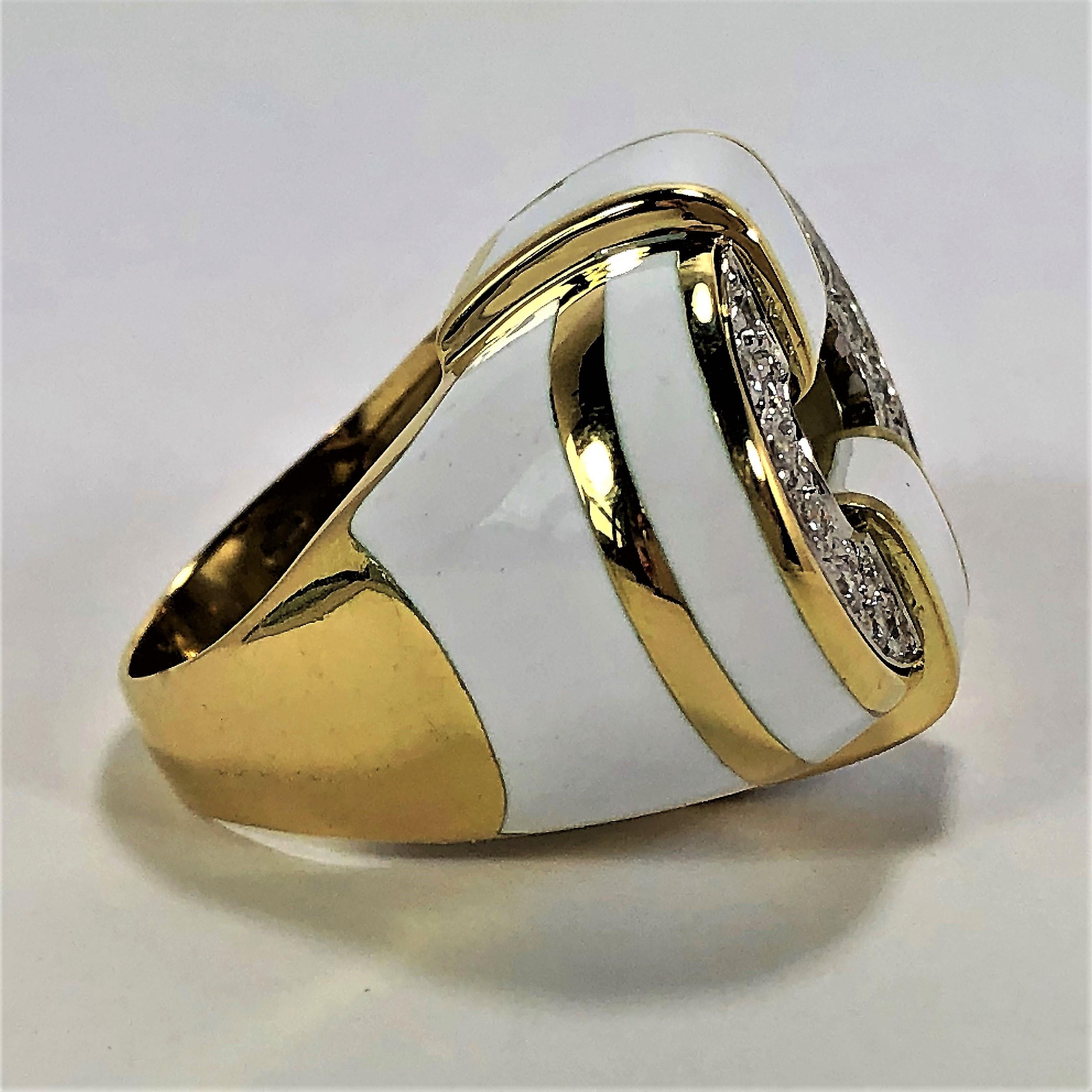 A ladies 18K yellow gold ring featuring a pave' set top, and white enamel. There are 26 round brilliant cut diamonds of overall G/H color and VS1/VS2 clarity and sparkle to the design. With a design area measuring 7/8 of an inch by 1 1/8 inches it