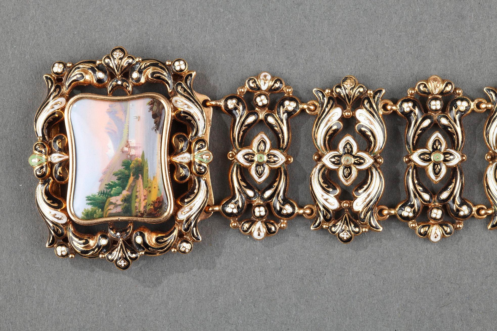Gold and enamel bracelet. The bracelet is composed of nine symmetrical medallions decorated with foliage and stylized flowers and accented with black and white enamel. The clasp is hidden by a rectangular medallion in enameled gold that features a