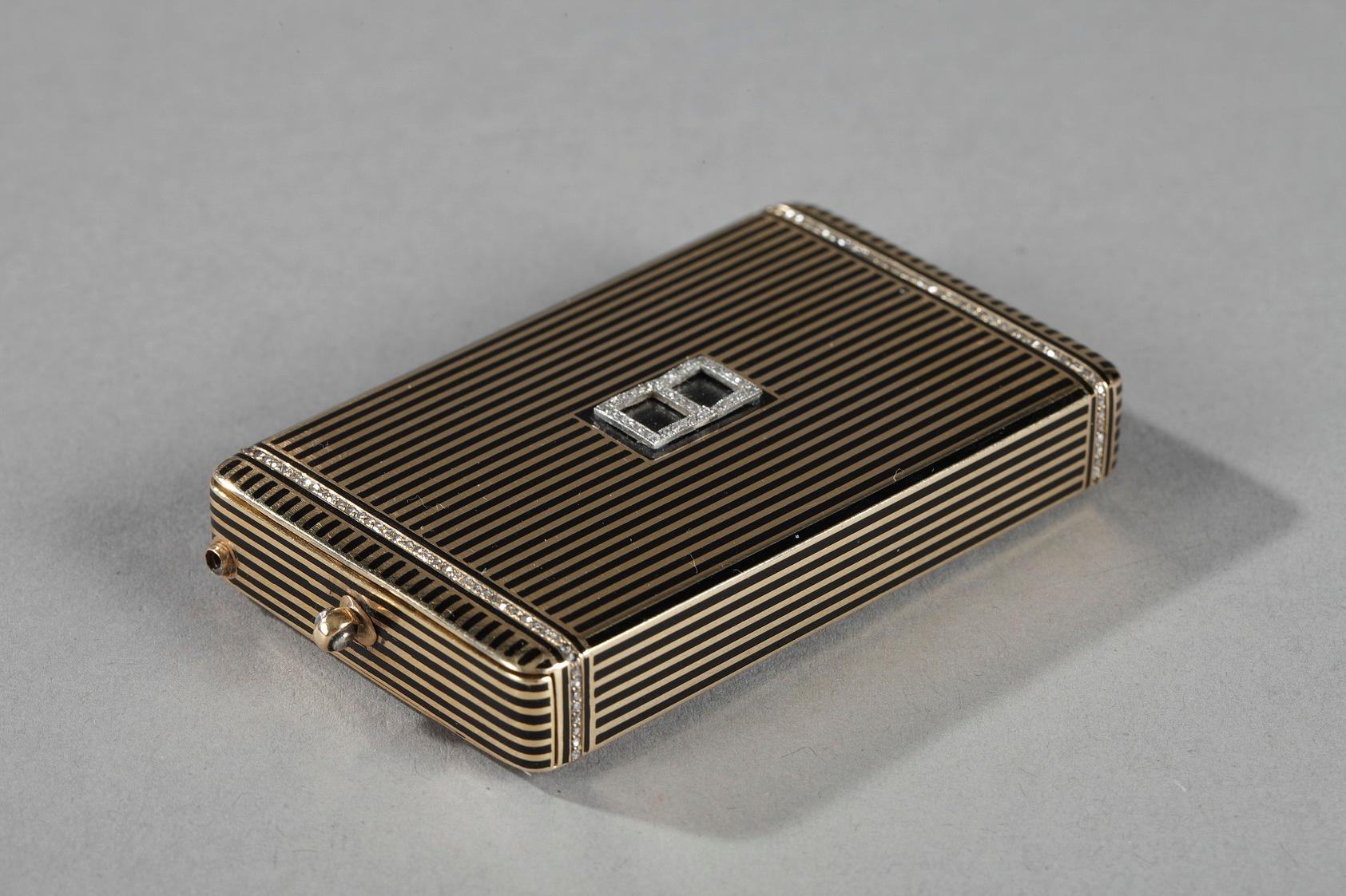 Mallette de minaudière rectangulaire en or émaillé. Il est orné de bandes alternées d'or et d'émail noir et cerclé d'une frise de petits diamants. La face principale du boîtier est décorée d'un motif géométrique de deux carrés d'émail noir encadrés