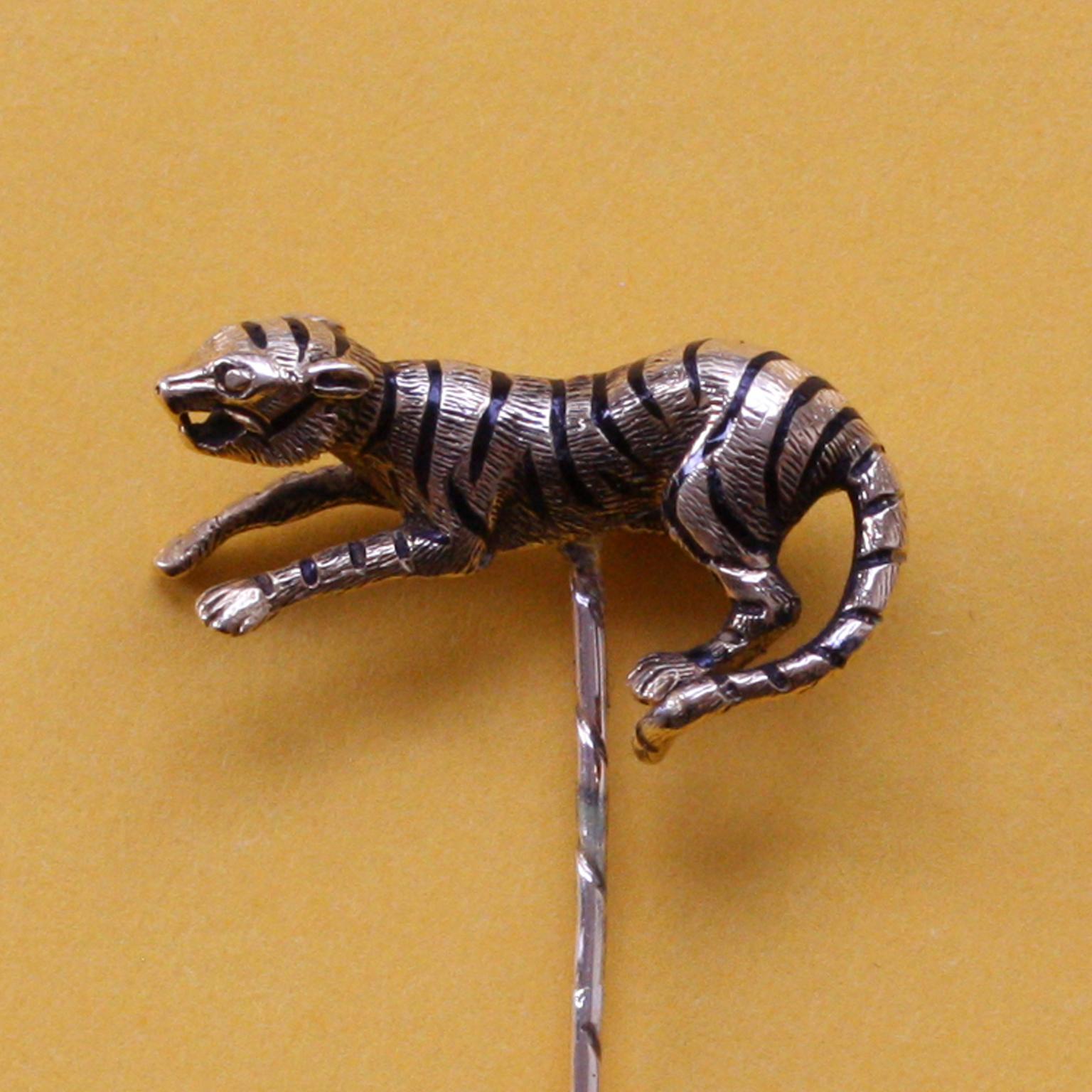 An 18 carat gold stickpin in the shape of a tiger with engraved hair and black enamel stripes, 19th century.

weight: 6.50 gram
dimensions tiger: 2.4 x 1.5 cm
length including pin: 5.9 cm