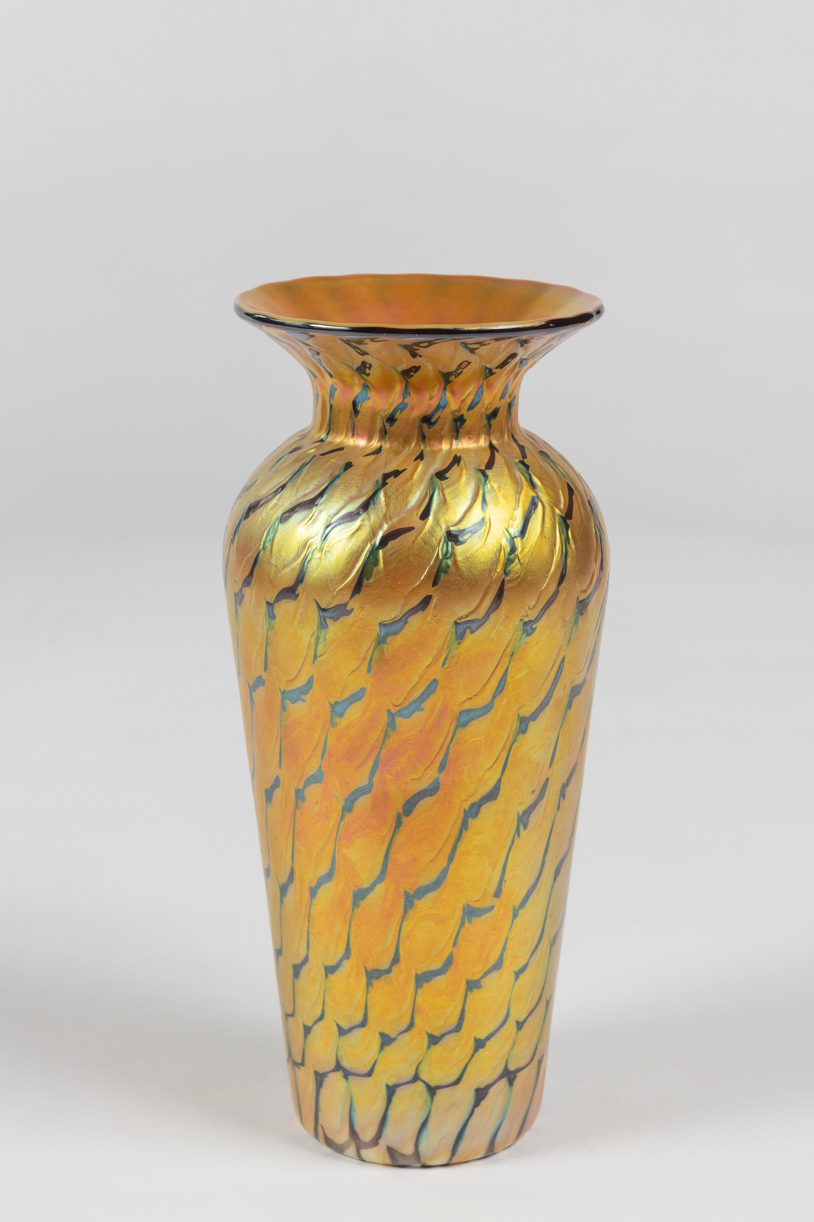 Ce vase en verre d'art irisé or et vert, d'une grande élégance, est fabriqué par les studios Lundberg de Californie et signé. Très bon état.