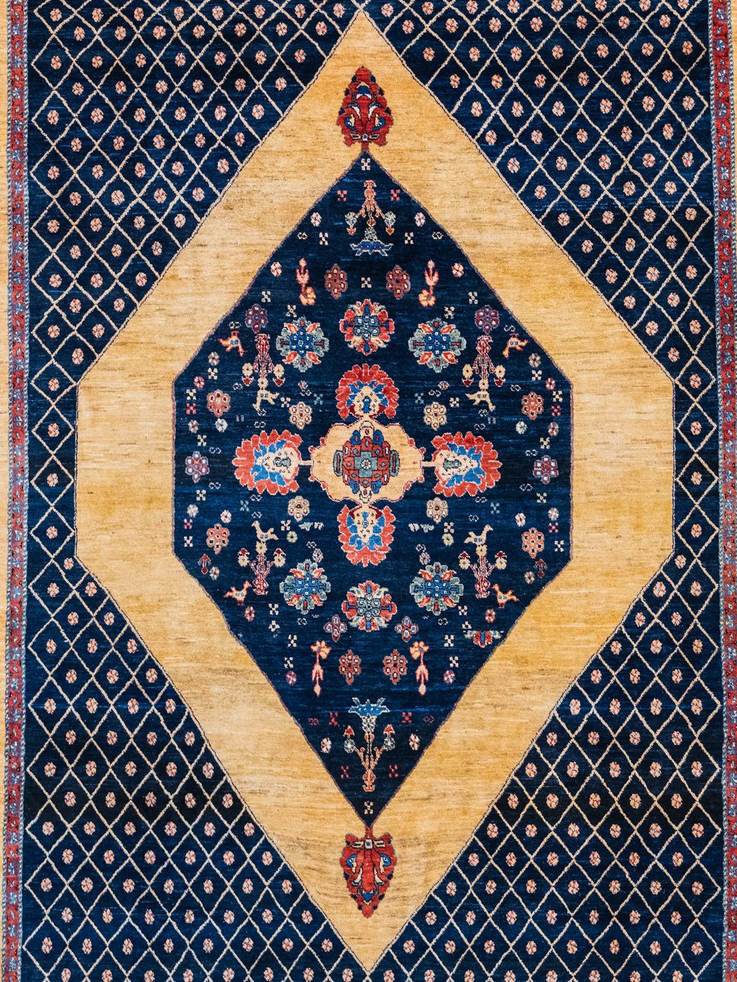 With an impressive and eye-catching floral medallion, this inviting and geometric carpet measures 7’2” x 9’4” and was woven in Iran circa 2013. Crafted with a Persian-inspired weave, this carpet’s woolen pile is plush, and luxurious, and possesses a