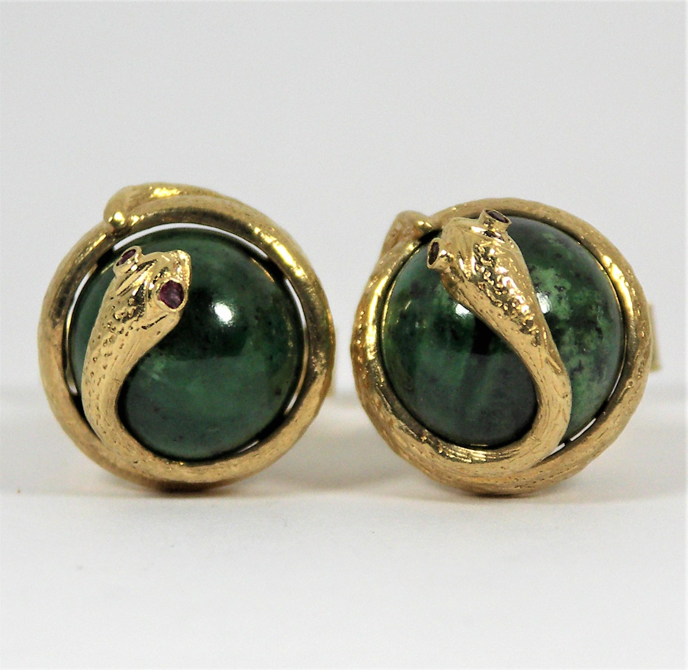 The two gold snakes are coiled around the Jade centers from head to tail, and are accented with ruby eyes. These unique cufflinks are made
of 14k Yellow Gold and have flip, toggle backs. They measure 1 3/8 inch in overall length by just under 3/4