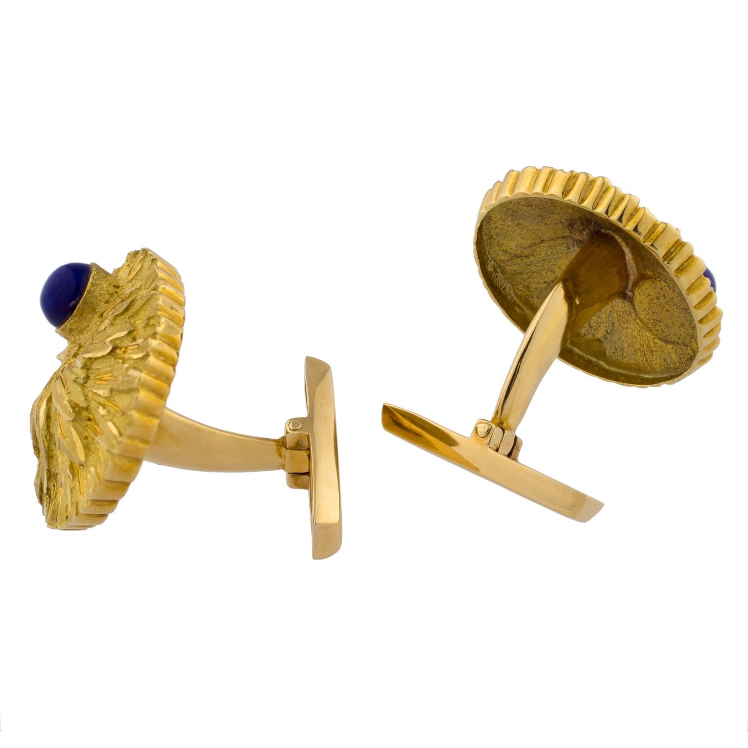 Round cufflinks in 18K yellow gold, with texturized leaf motifs, decorated with two cabochon lapis lazulis.
Diameter: 22 mm (0.87 in)