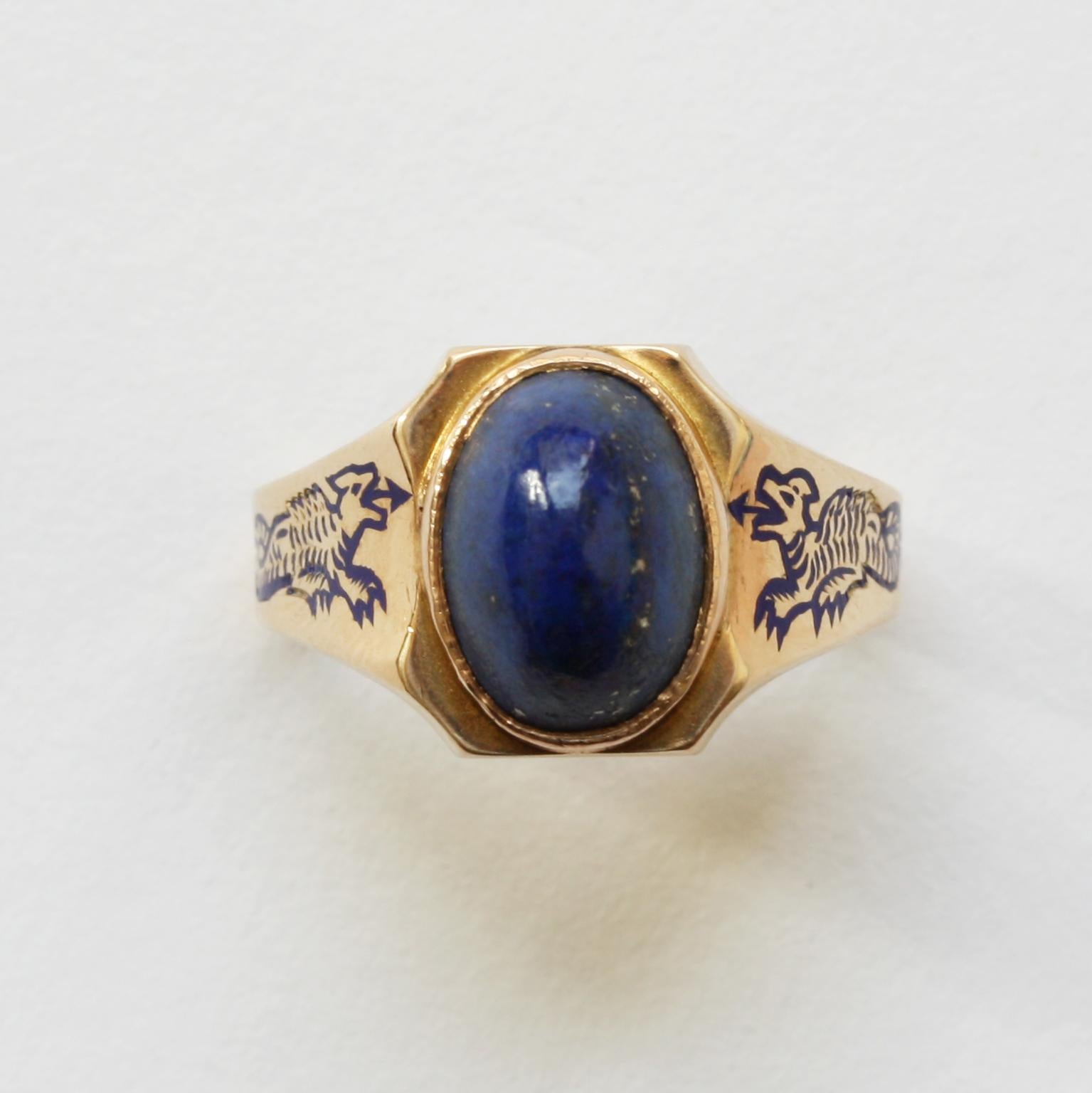 A 14 carat gold Art Deco ring set with a high oval cabochon cut lapis with pretty little flakes of pyrite on each side in the shank is a little dragon in blue enamel, circa 1920, American.

ring size: 16.25 – 16.5 mm. / 5 ½ US
weight: 5.72