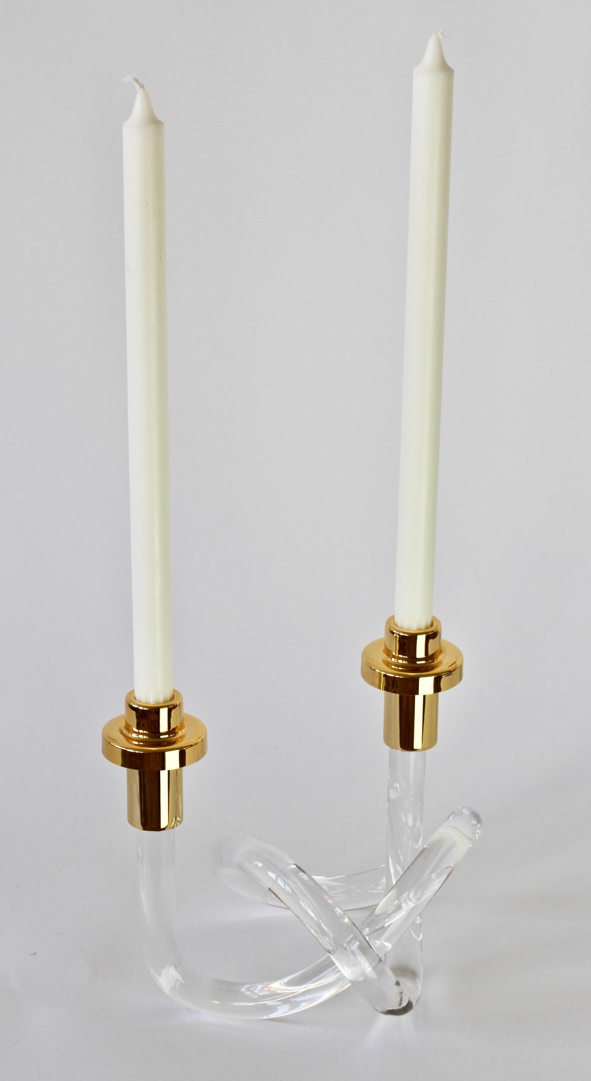 A vintage midcentury Lucite and gold-plated brass double candlestick holder/candelabra designed by Elaine Bscheider for American designer Dorothy Thorpe, circa 1950s. With it's use of a single piece bent and twisted acrylic to form the whimsical
