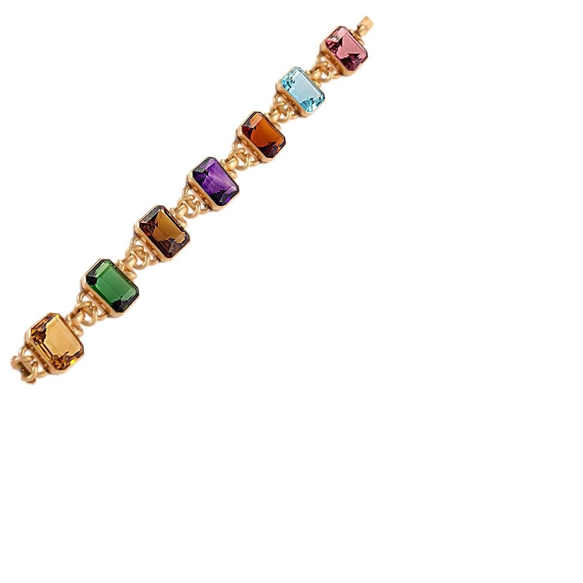 An Estate 18 karat gold bracelet with amethyst, aquamarine, citrine and garnet. Each of the gemstones in this fetching, fun yet elegant bracelet are equally sized, and connected with stylized gold links, adding a subtle element of design to the