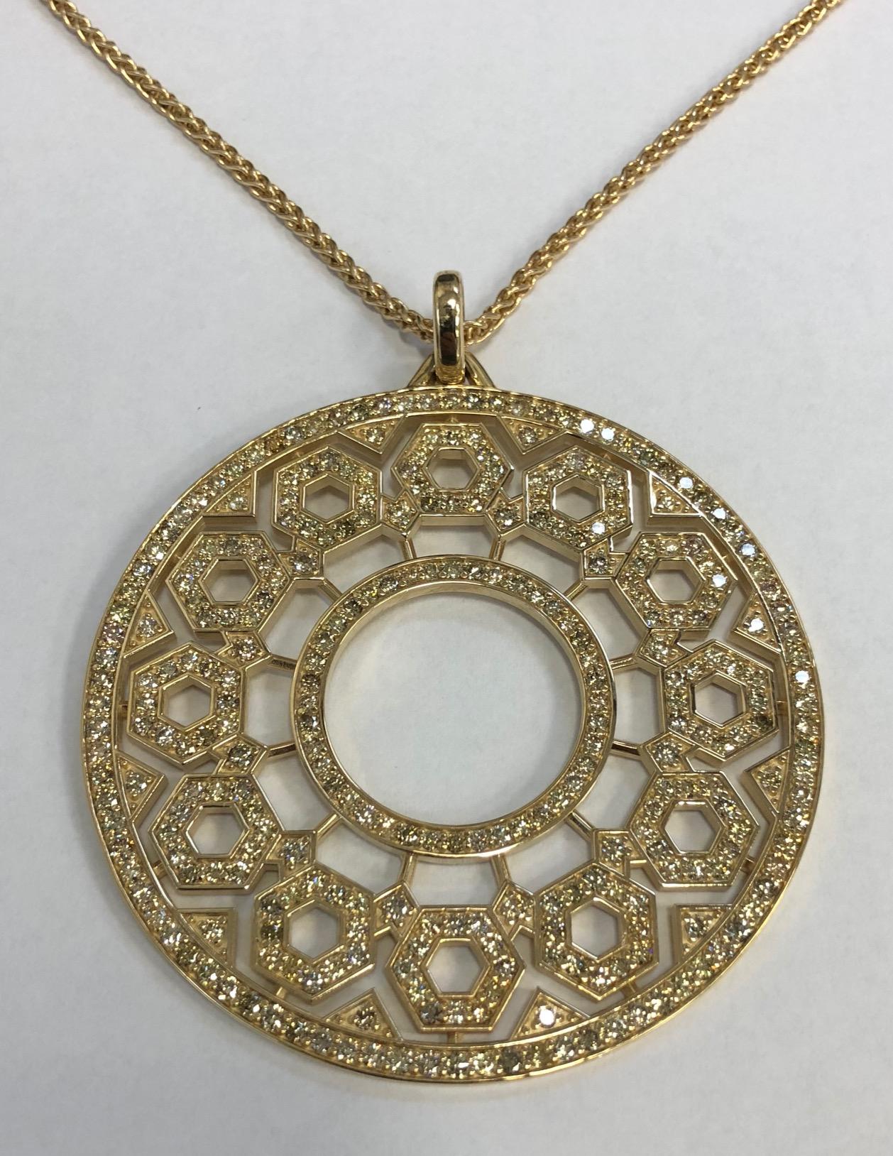 The 14K gold and diamond pendant is quite a large and bold statement. Measuring over 2.5 inches in diameter, It is bead set with 8.85 carats of natural fancy yellow and brown diamonds in varying shades. Inspired by the geometric design of manhole