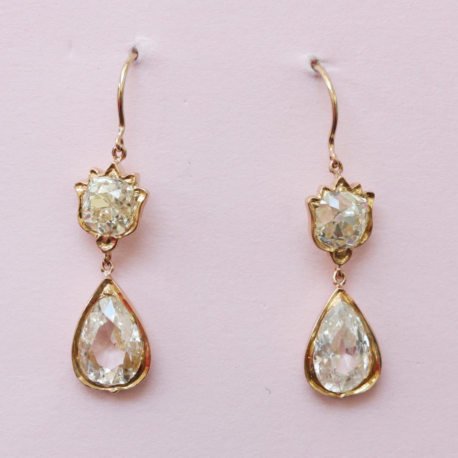 A pair of 18-carat gold earrings with an old-cut round, and a pear-shaped diamonds (app. 5.4 carats in total) with gold tulip decorations. The watery diamonds used in Indonesian jewellery mostly came from Borneo and the stones were often cut in