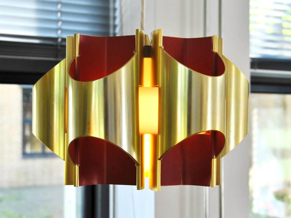 Diese atemberaubende und ziemlich seltene Pendelleuchte wurde von Bent Karlby für Lyfa in Dänemark entworfen. Es besteht aus 6 Röhren aus goldfarbenem Aluminium mit einer roten Innenseite. Die röhrenförmigen Teile lassen sich wie bei der