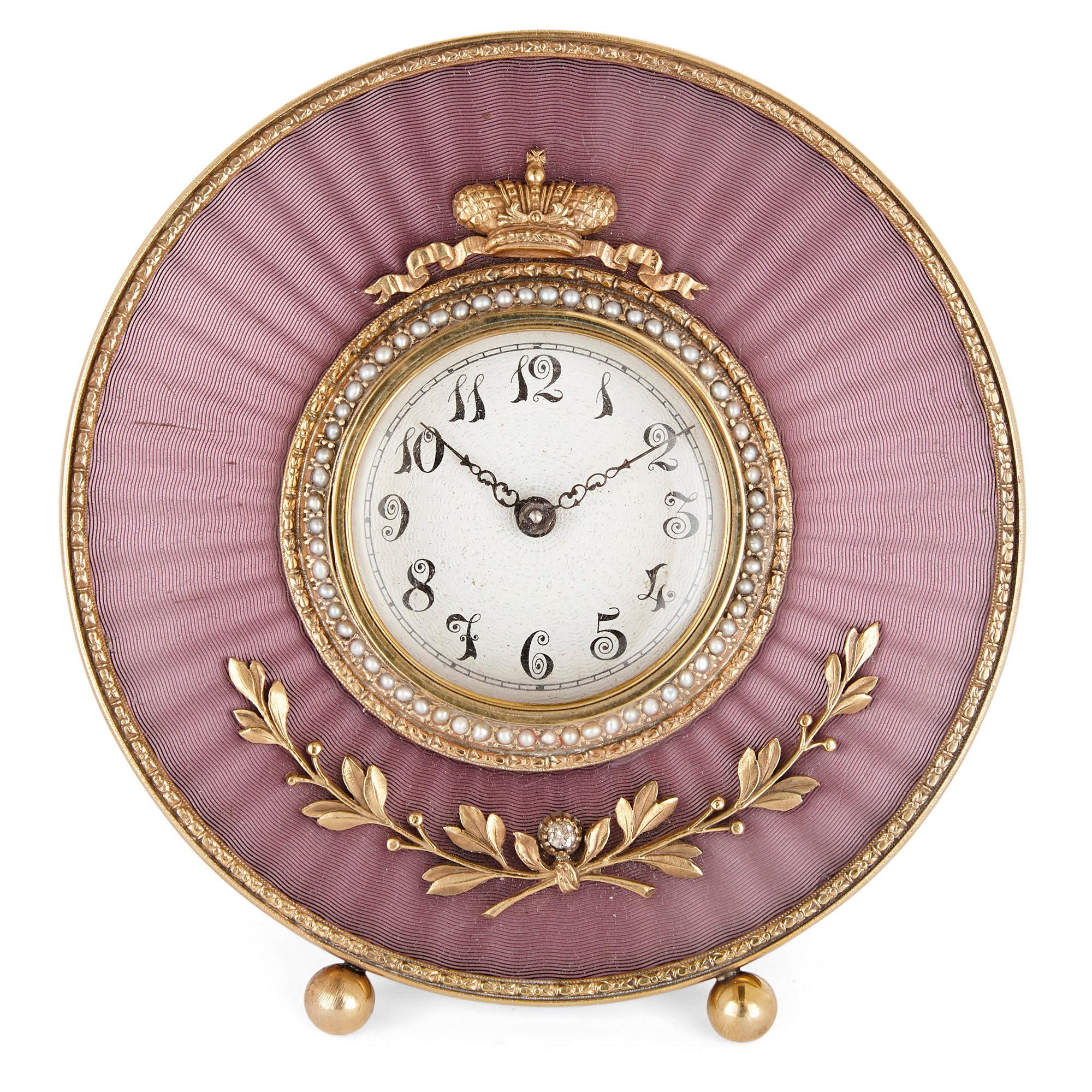 This circular shaped table clock is created in the manner of Fabergé. The surface of the clock has been finished with exquisite guilloché enamel, the circular outer edge of which being framed by a gold foliate band. The dial, inscribed with Arabic