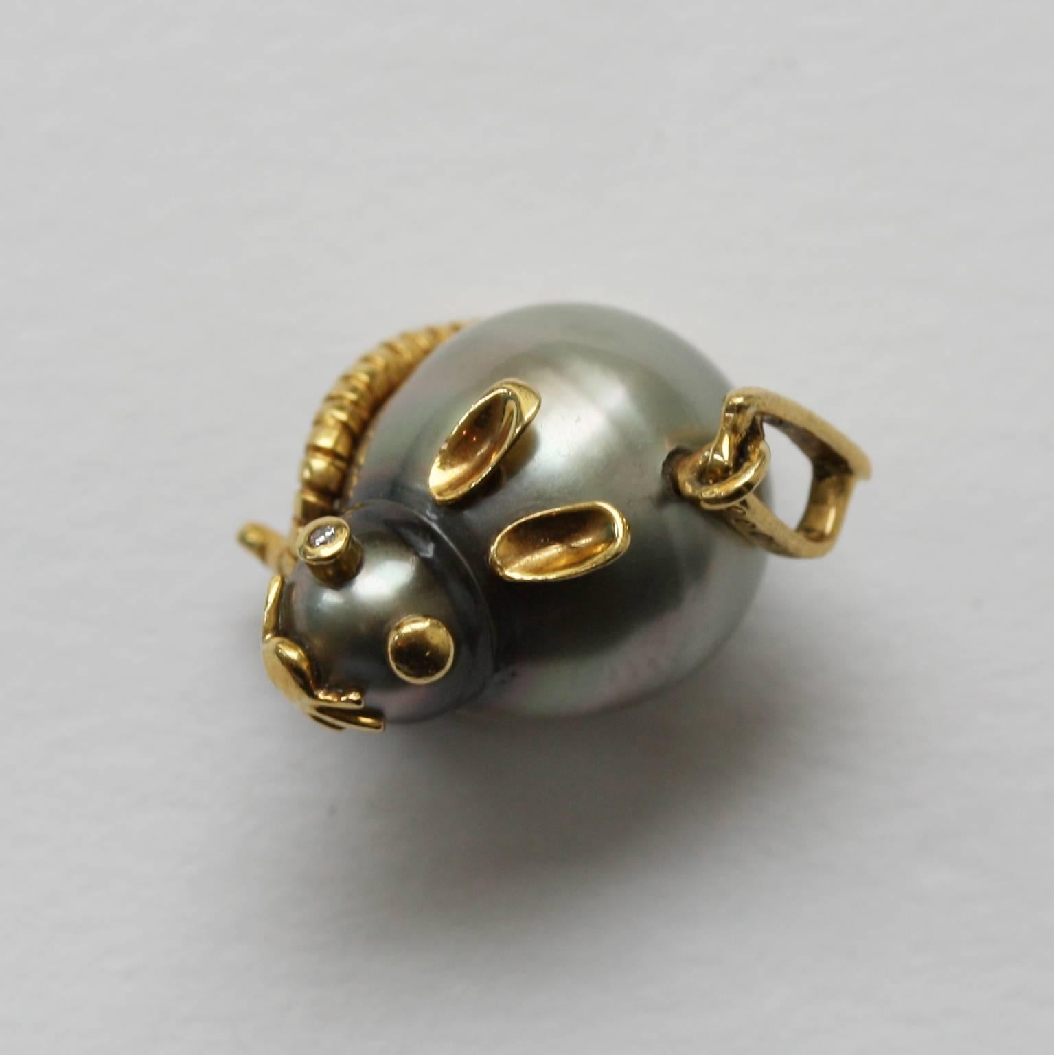 A mouse charm, its body and head consists of one grey Tahiti pearl, the head a little smaller then the body, its ears, snout, eyes and whiskers are 18 carat gold, with two small brilliant cut diamonds in its eyes, French.

gewicht: 5.52 gram