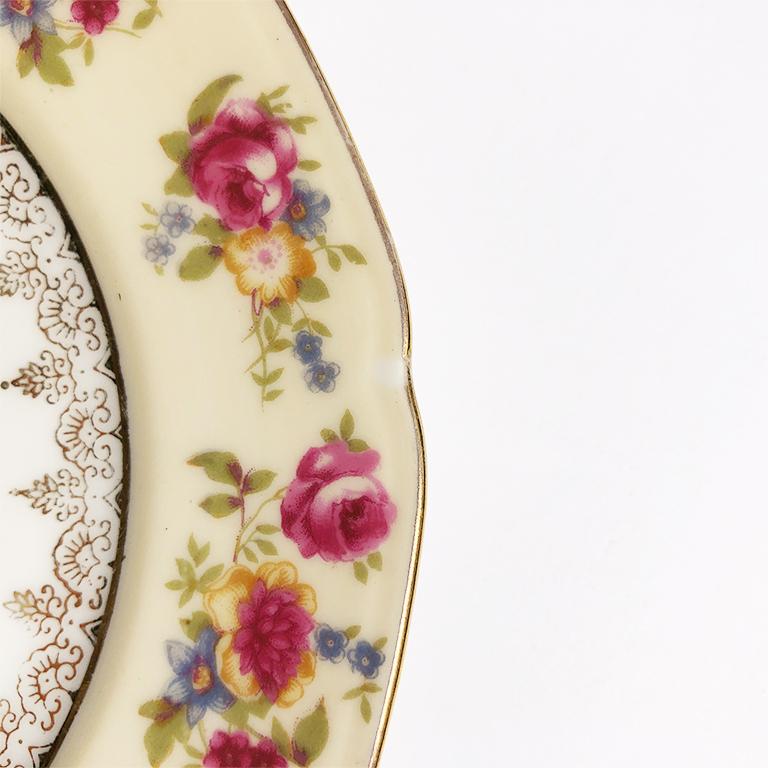 Beautiful floral plate with scalloped edges. The piece features roses and other flora throughout and gold designs around the rim and in center. The bottom reads: Gold Castle made in Occupied Japan. A beautiful piece to elevate your summer