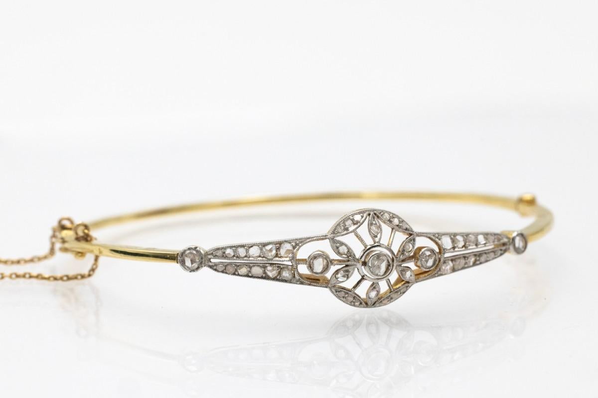 Old rigid bracelet made of 18-karat yellow gold (750 fineness) and platinum. The openwork front of the bracelet is set with rose-cut diamonds.

Origin: Western Europe, circa 1920.

Very good condition, without damage.

Internal dimensions: 58 x 49