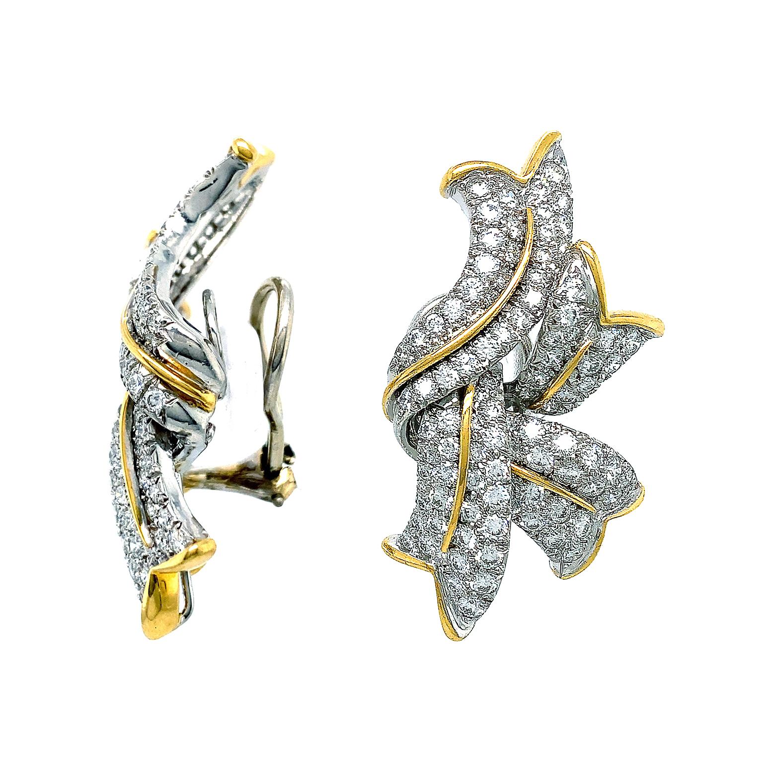 The rhythm of flames are the inspiration for these earrings. Thick strands with V-shaped ends sweep past each other and overlap in a fanciful arrangement. Platinum forms the strands, which are embellished with brilliant cut diamonds. 18k yellow gold