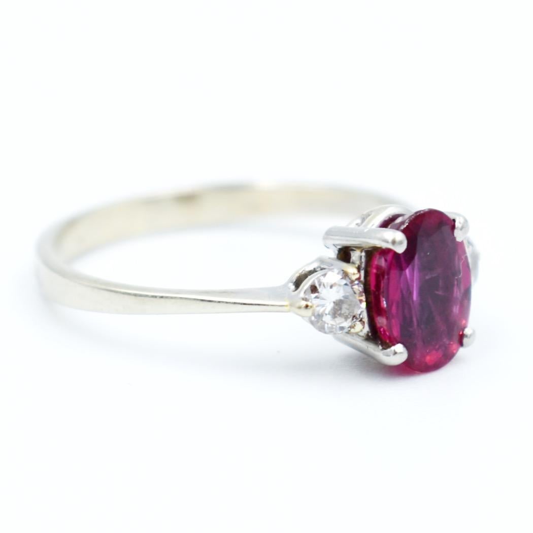 Art Deco ring in 18k gold and platinum. It is made up of three stones, a natural ruby ​​of approximately 1 carat (0.8 x 0.6 x 0.3) deep color and very good quality,
 two diamonds surrounding it on each side of approximately 0.10 carat.
The ring is