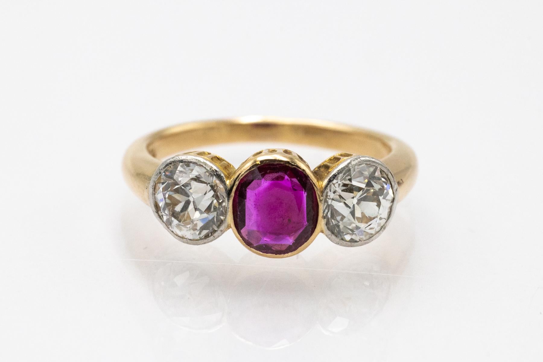 Un bellissimo anello vintage realizzato in oro giallo 18 carati (finezza 0,750) con elementi in platino e diamanti incastonati. Adornato da un rubino naturale centrale di 0,65 ct, circondato da due diamanti antichi taglio brillante di 1,80 ct (ogni