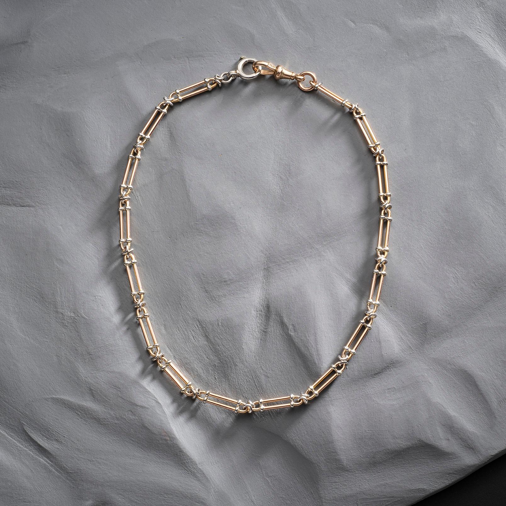 This Trombone link Albert chain, crafted in rose gold and platinum, exudes classic sophistication. 

Albert chains, named after Prince Albert, emerged in the 19th century as practical yet stylish watch chains. The trombone link, with its elongated,