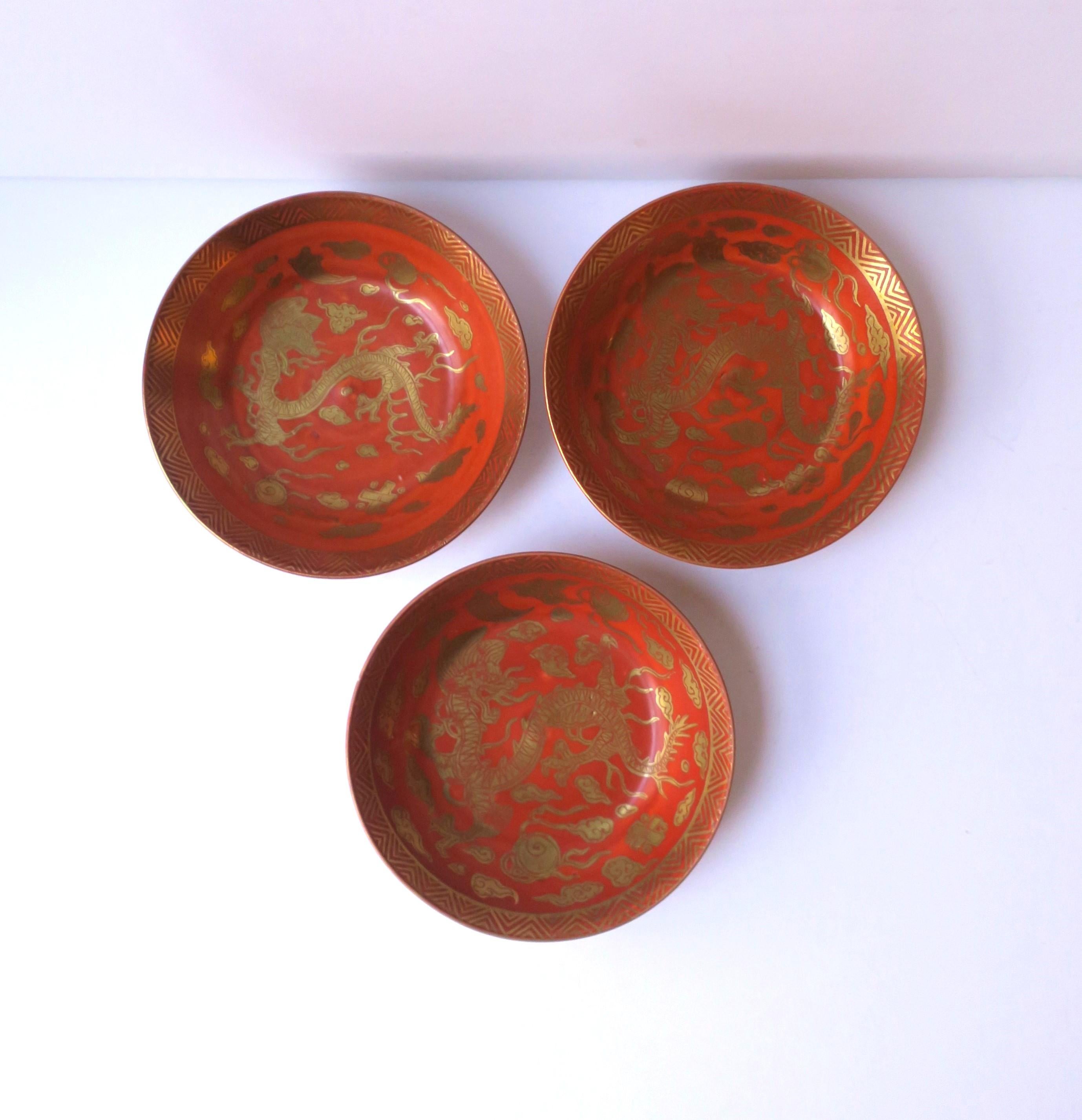 A set of three (3) Japanese porcelain gold and red finger or nut bowls with dragon design, circa mid-20th century, Japan. Beautiful dragon detail with fire flaming tongue and chevron-like design around edge. A great set for entertaining; nuts,