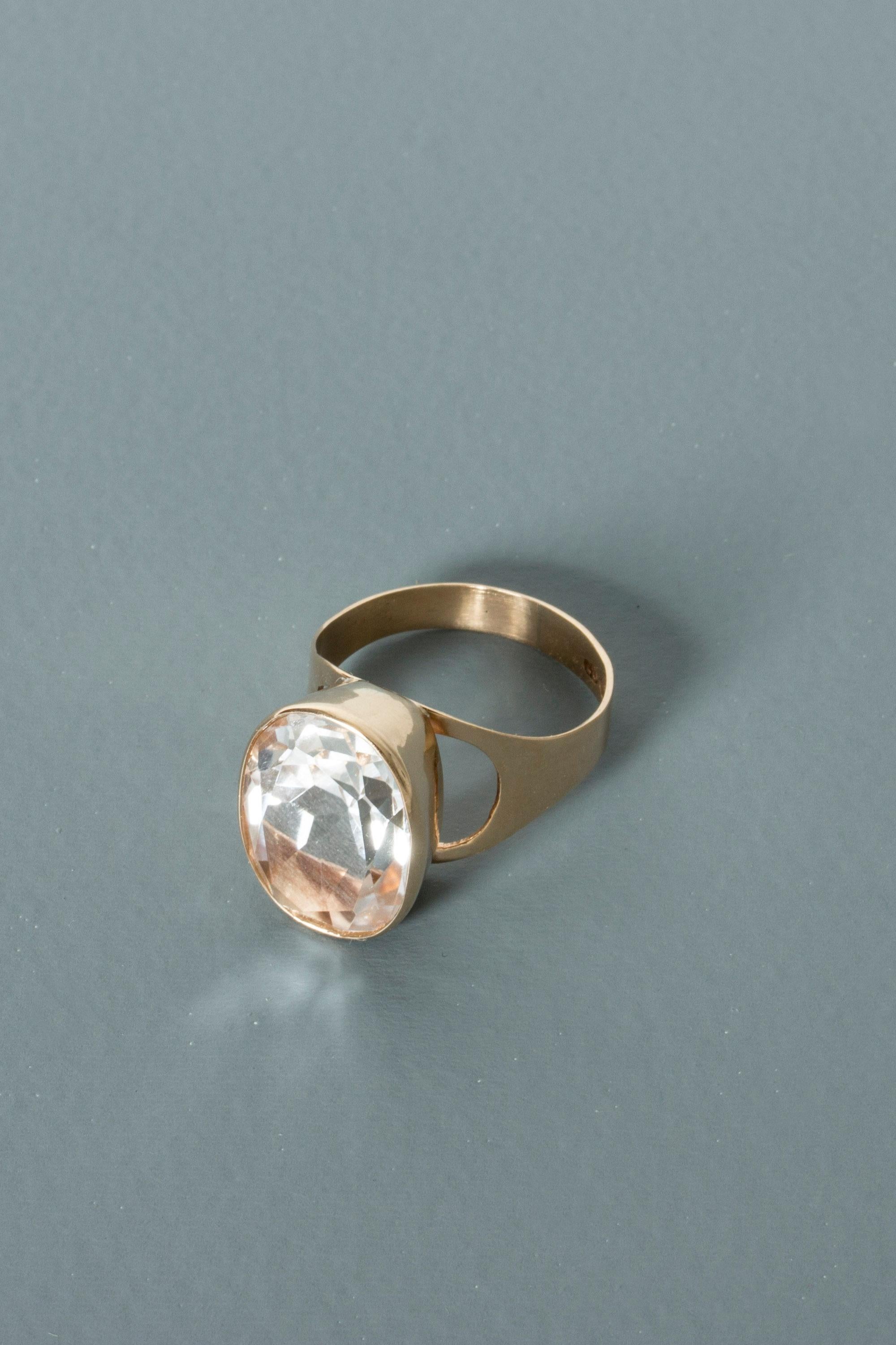 Beautiful gold ring by Tauno Suhonen, with a brilliant, oval rock crystal. The frame has elegant openings on the sides to let the light in.
