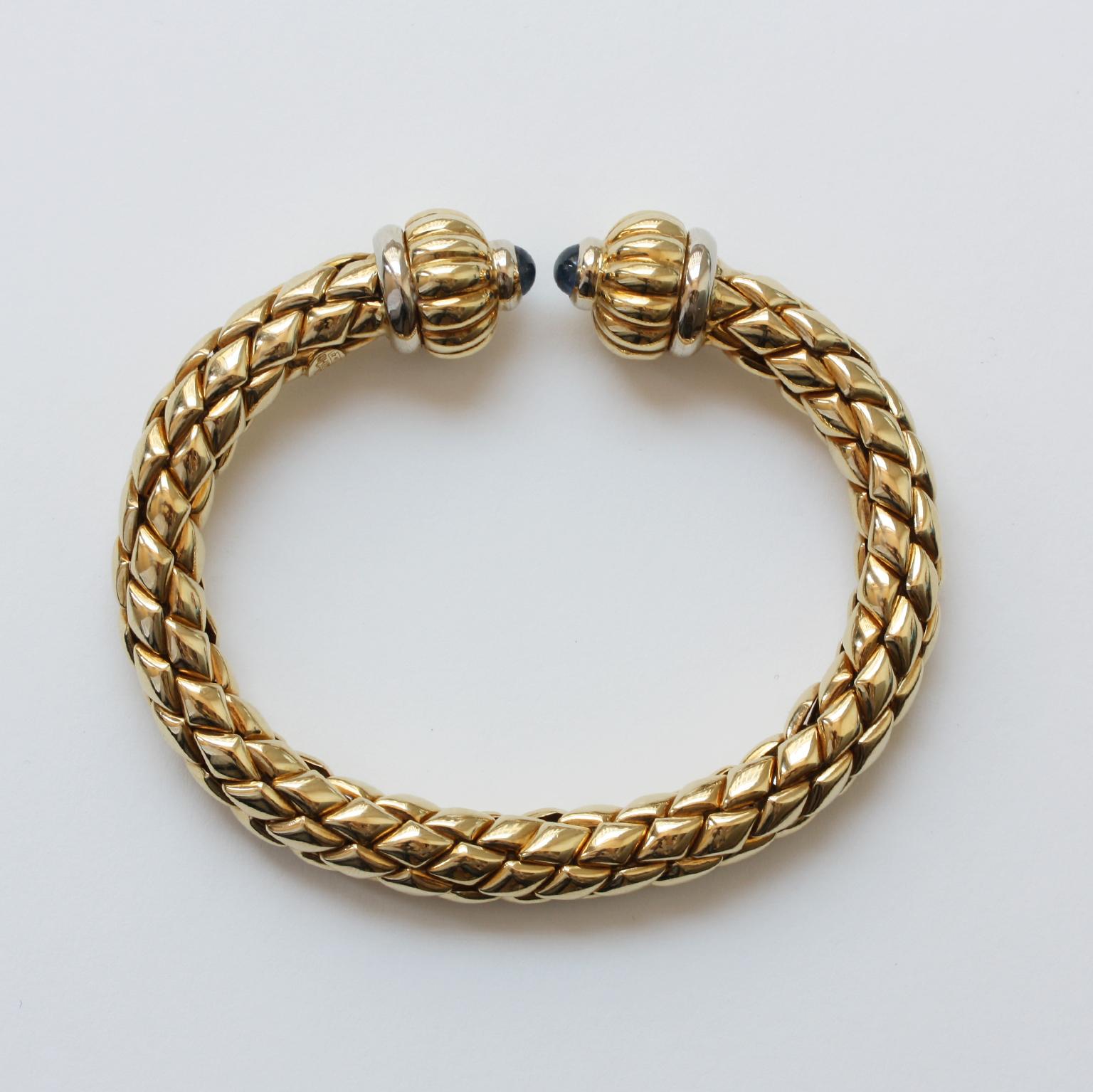 An 18 carat gold bracelet bangle, flexible round woven with two open ends, on each and a turban decoration with yellow and white gold and a cabochon cut sapphire, signed Chimento, Italy, circa 1980.

dimensions: 6 x 4.2 cm
circumference: 16.5 cm