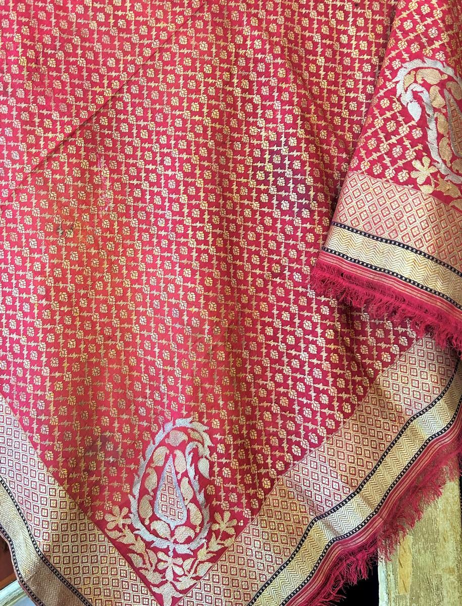 Segunda mitad del siglo XIX
India

Precioso chal cuadrado indio de seda rosa bordado con tiras de oro y plata, producido en el norte de la India en el siglo XIX, sobre todo en Benarés (Benarés), en Uttar Pradesh. Campo central relleno de una celosía