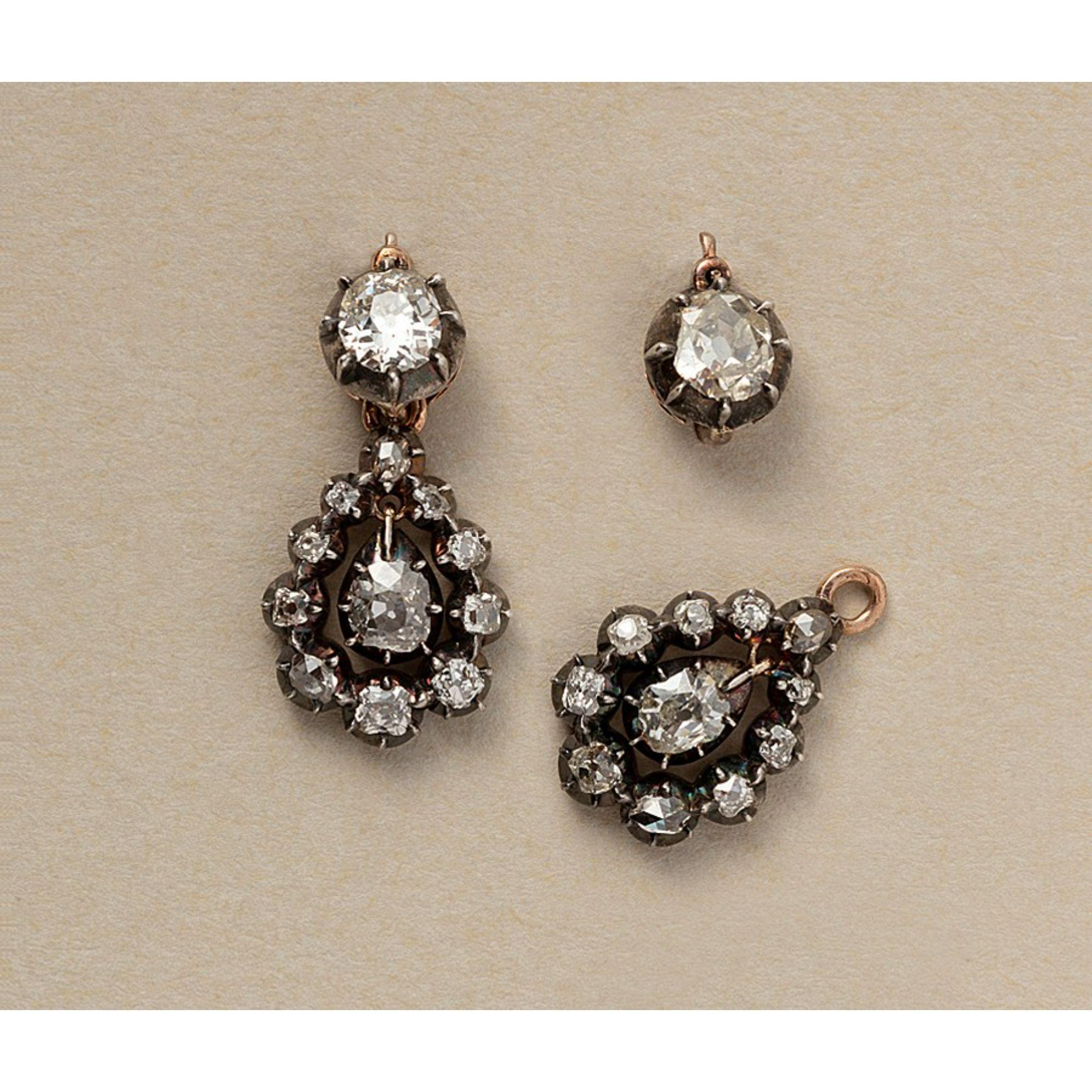 A pair of 18 carat rose gold and silver – day and night – earrings, set with two bigger old cut diamonds on the hook and a detachable pear shaped element of old cut diamonds, descending in size and one oval, old cut diamond dangling in the middle