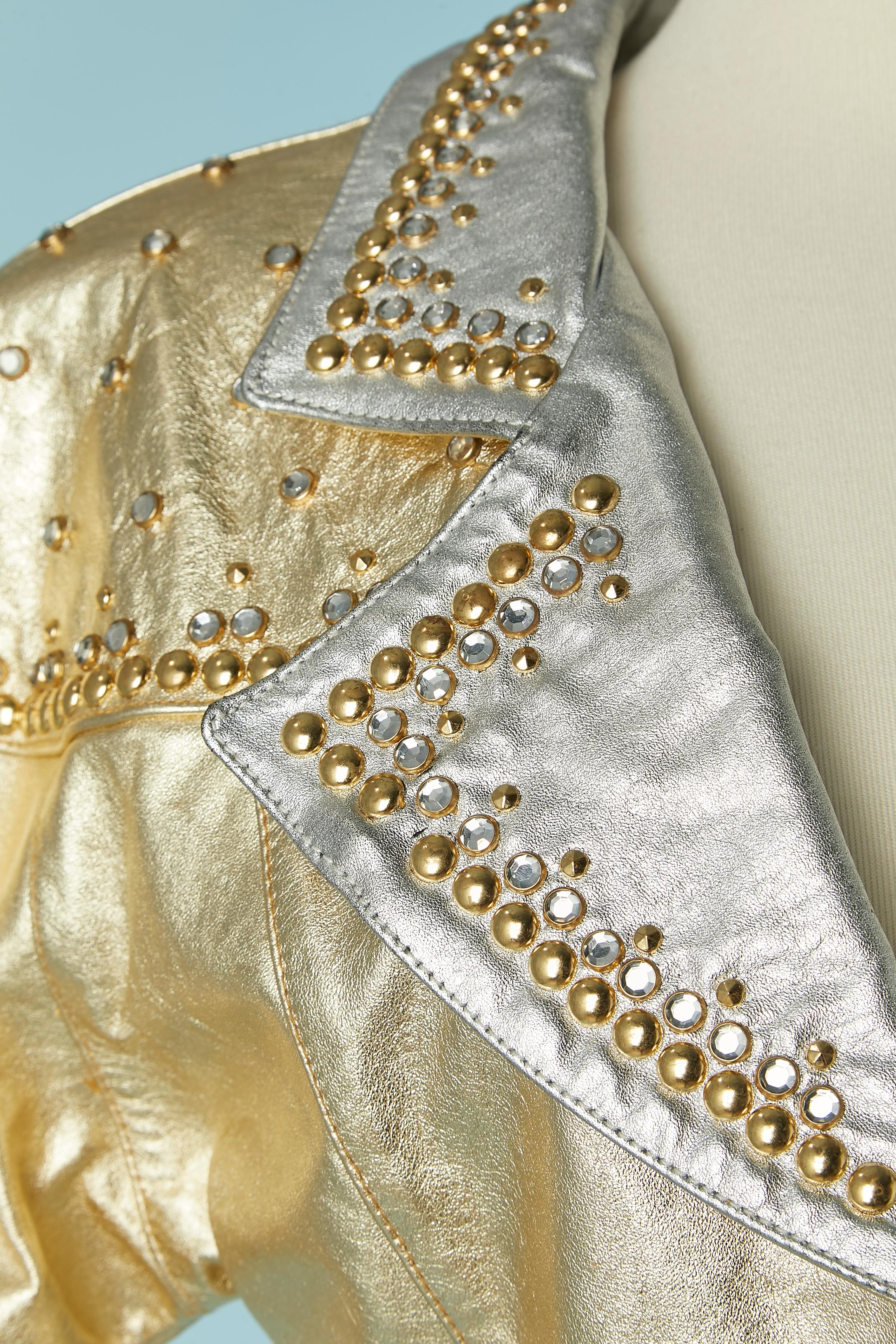 Giacca in pelle oro e argento con borchie e strass. Non c'è l'etichetta della composizione del tessuto per la fodera, ma probabilmente si tratta di rayon. 
TAGLIA S 