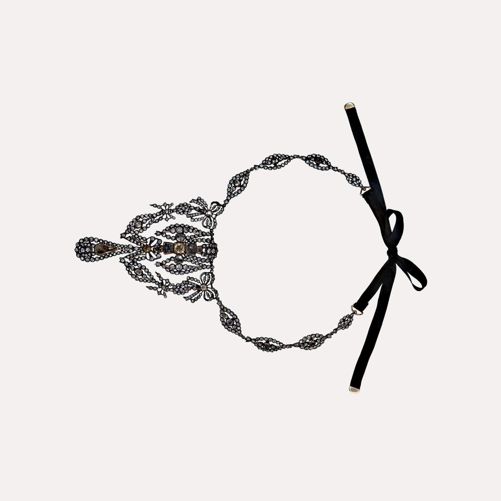 
Gold and silver necklace set with quartz, citrines and strass. Cross flanked by lacings with drop pendant and satin ribbon with gold terminals. Necklace length 31.5cm, total length with satin ribbon 80.5cm. Restorations. Portuguese, Without