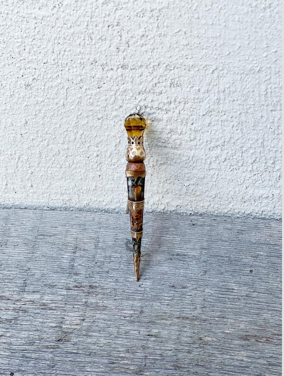 One 9 karat rose gold and sterling silver (acid tested) Scottish Dirk pin.  The pin features four custom pieces of agate and three faceted citrines. The figural dirk knife or dagger-shaped brooch measures 2.5 inches long and is complete with a