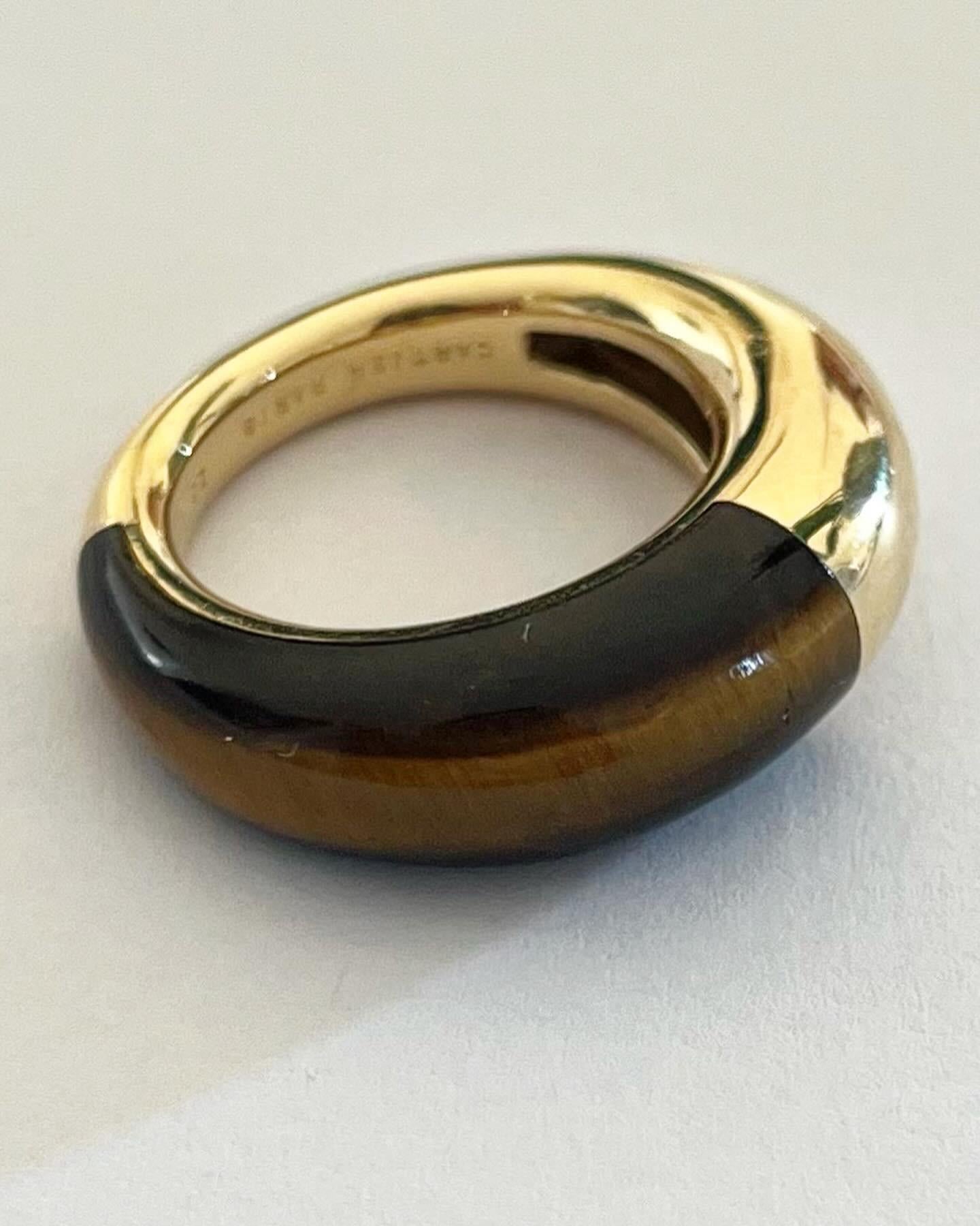 A Modern look that's really the cat's meow, this designer Cartier tiger's eye ring is totally on trend. Sleek high polish yellow gold forms a simple style which is bisected at the top with a tawny toned tiger's eye. Circa 1980 - Stamped Cartier

The