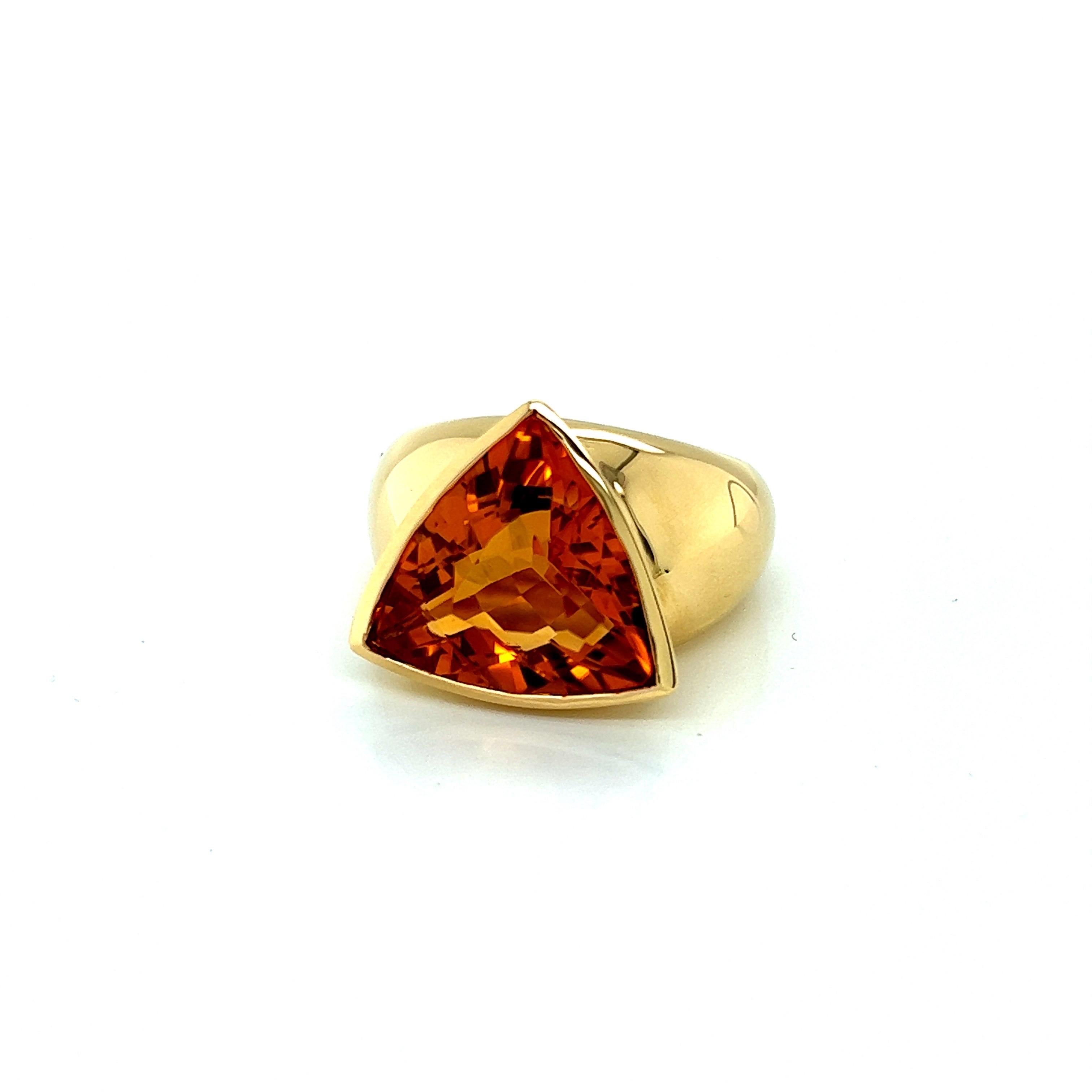 Questo anello in oro giallo 18 carati presenta una splendida pietra citrina a forma di trilione che catturerà l'attenzione di chiunque la veda. La pietra citrina è tagliata e lucidata con cura per massimizzare la sua brillantezza, creando un