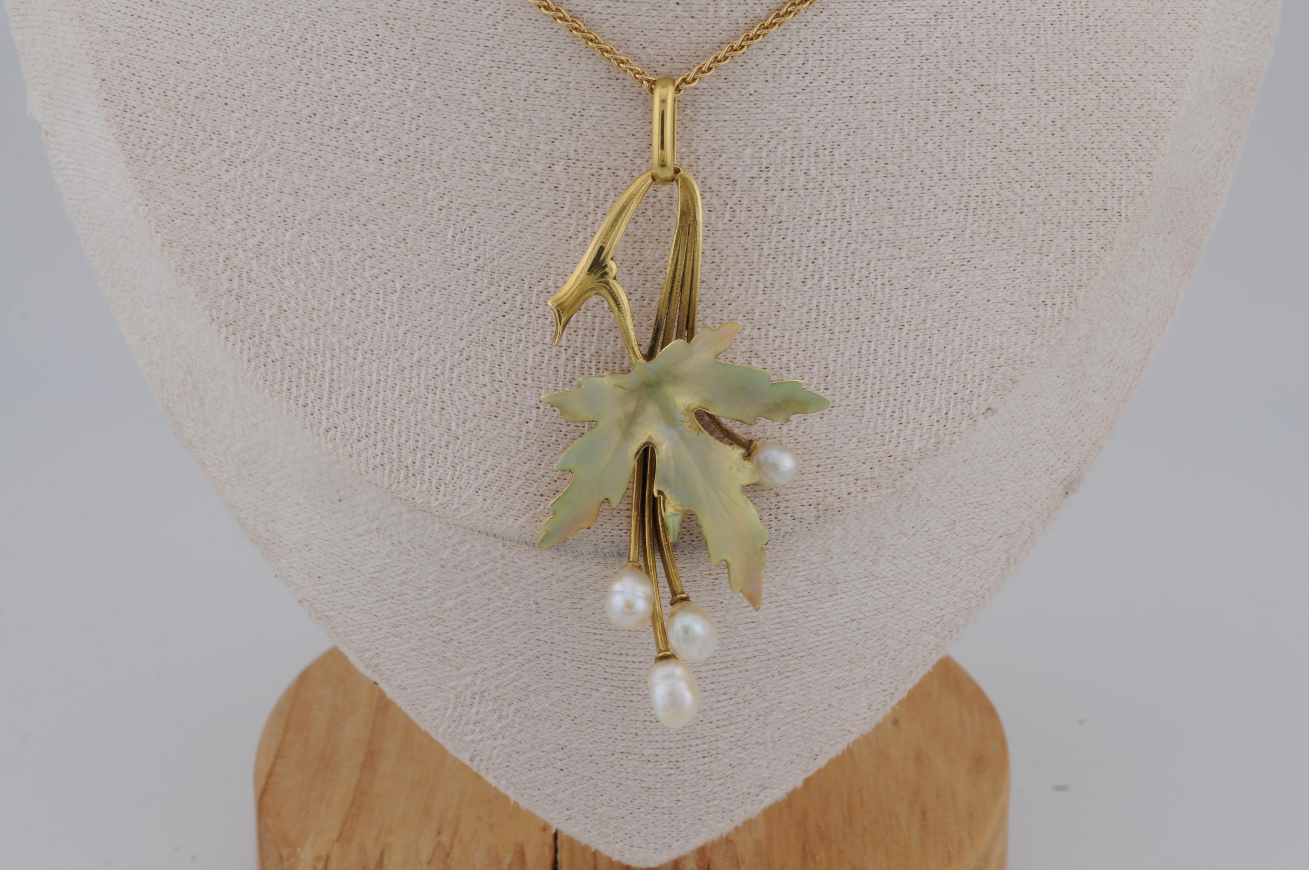 Jugendstil-Anhänger aus 18 Karat Gelbgold in Form eines stilisierten Ahornblatts. Der Anhänger ist mit schillernder Emaille verziert, die einen subtilen, schimmernden Farbeffekt erzeugt. Wunderschöne Naturperlen ergänzen das Design, während