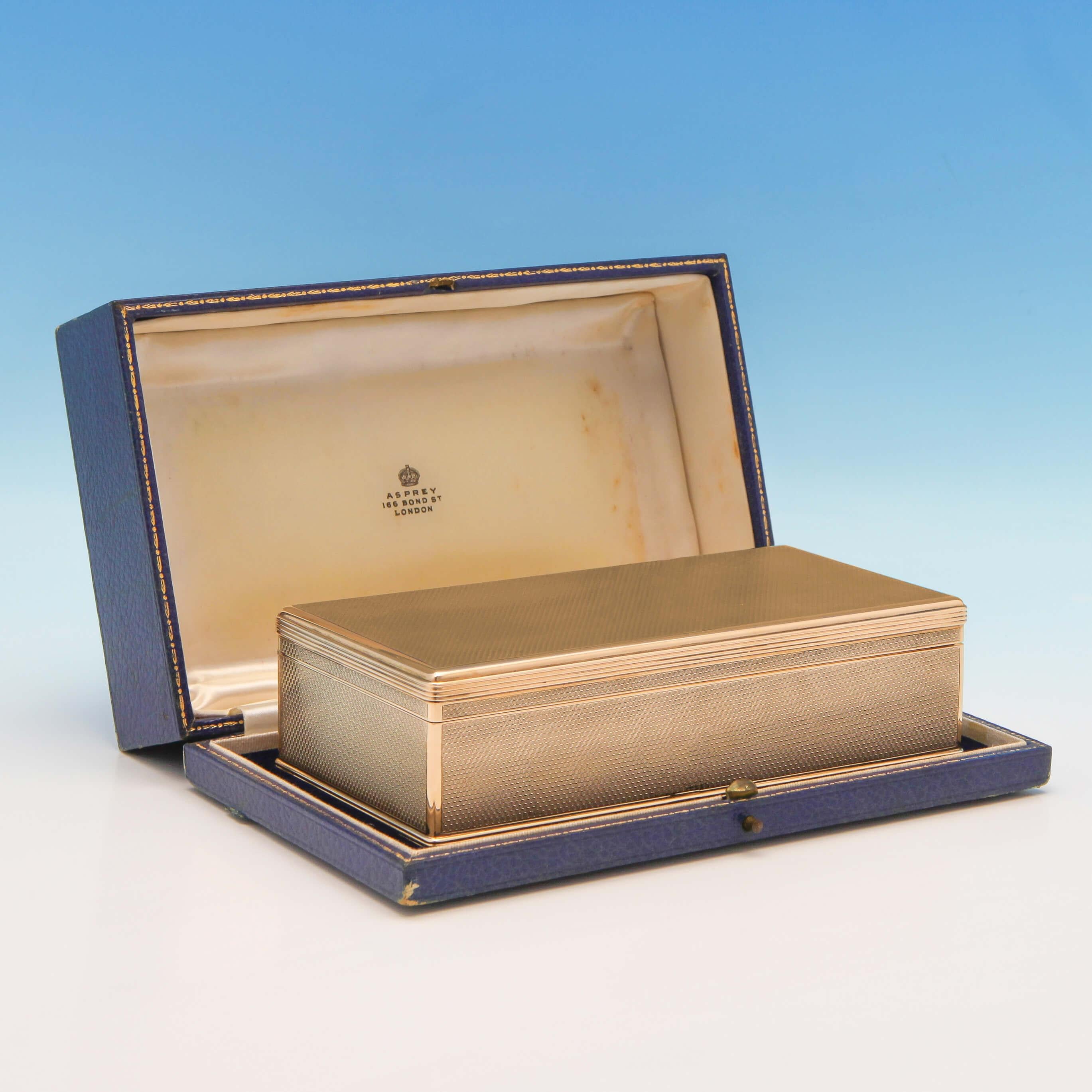 Hallmarked in London in 1928 by Asprey & Co. Ltd. This rare 9-carat gold cigar box has engine turned decoration and reeded borders. The box is cedar lined and comes in its original presentation box. There is an inscription on the inside lid