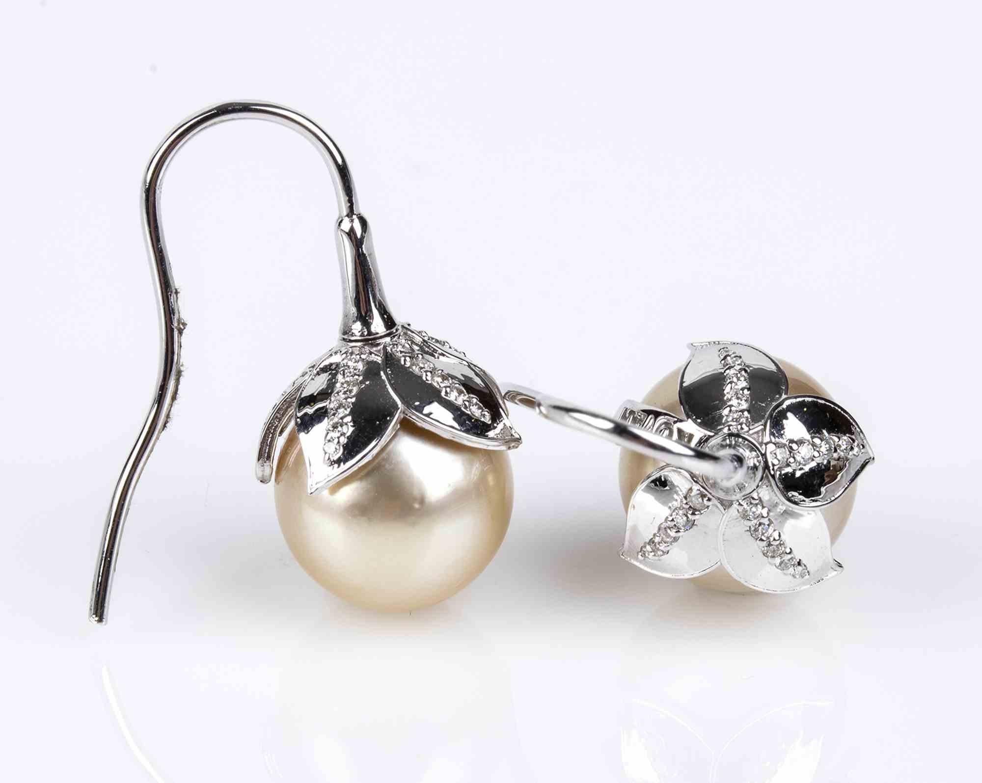 Gold, Australian pearl and diamonds earrings

Each with Australian pearl surmounted by leaf shape brilliant cut pavé set diamonds ca. 0.24 ct total, G, VVS. Length 25 mm, pearls diameter 11.5-12 mm. Weight 9.1 gr.
18k white gold.
Item condition