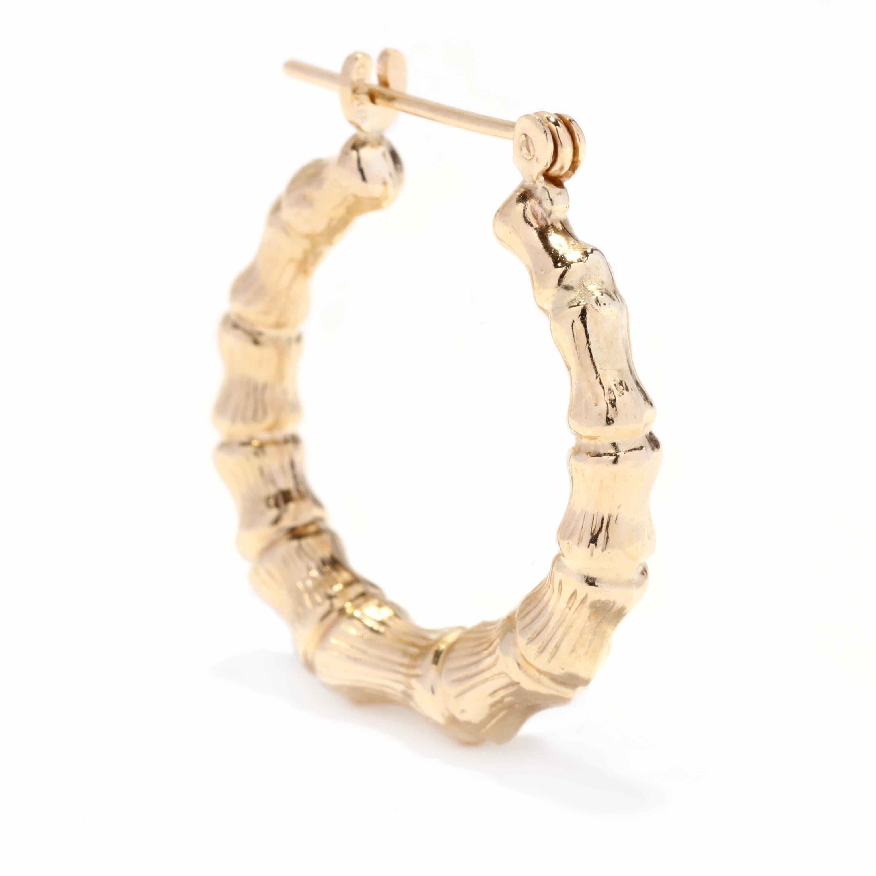 A pair of vintage 14 karat yellow gold bamboo hoop earrings. These earrings features a tapered circular design in a textured bamboo motif with latch back closures.

Length: 7/8 in.

Tube Width: 4.4 mm

Weight: 1.5 dwts



Ring Sizings &