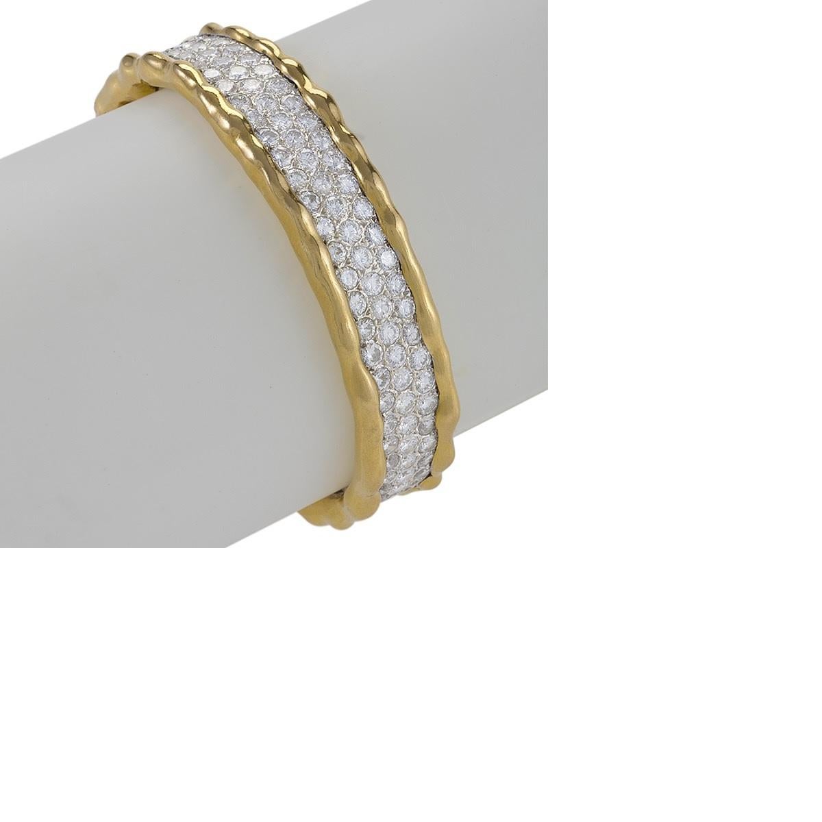 A French 18 karat gold bangle bracelet with diamonds by Van Cleef & Arpels. The Lascaux bangle bracelet has 141 round brilliant-cut diamonds with an approximate total weight of 13.0 carats. The have a G/H color and VS clarity grade.
 Circa