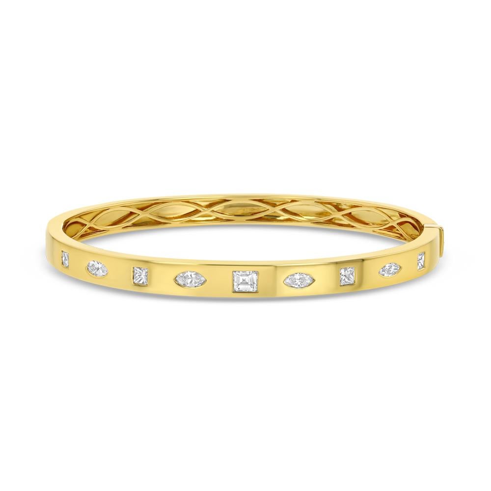 This 18 karat yellow gold bangle with an array of flush set multi shaped diamonds is a joyous modern twist to a classic design. Perfect for layering or great on its own this piece is versatile and exquisite.  


(18k yellow gold and 9 white diamonds