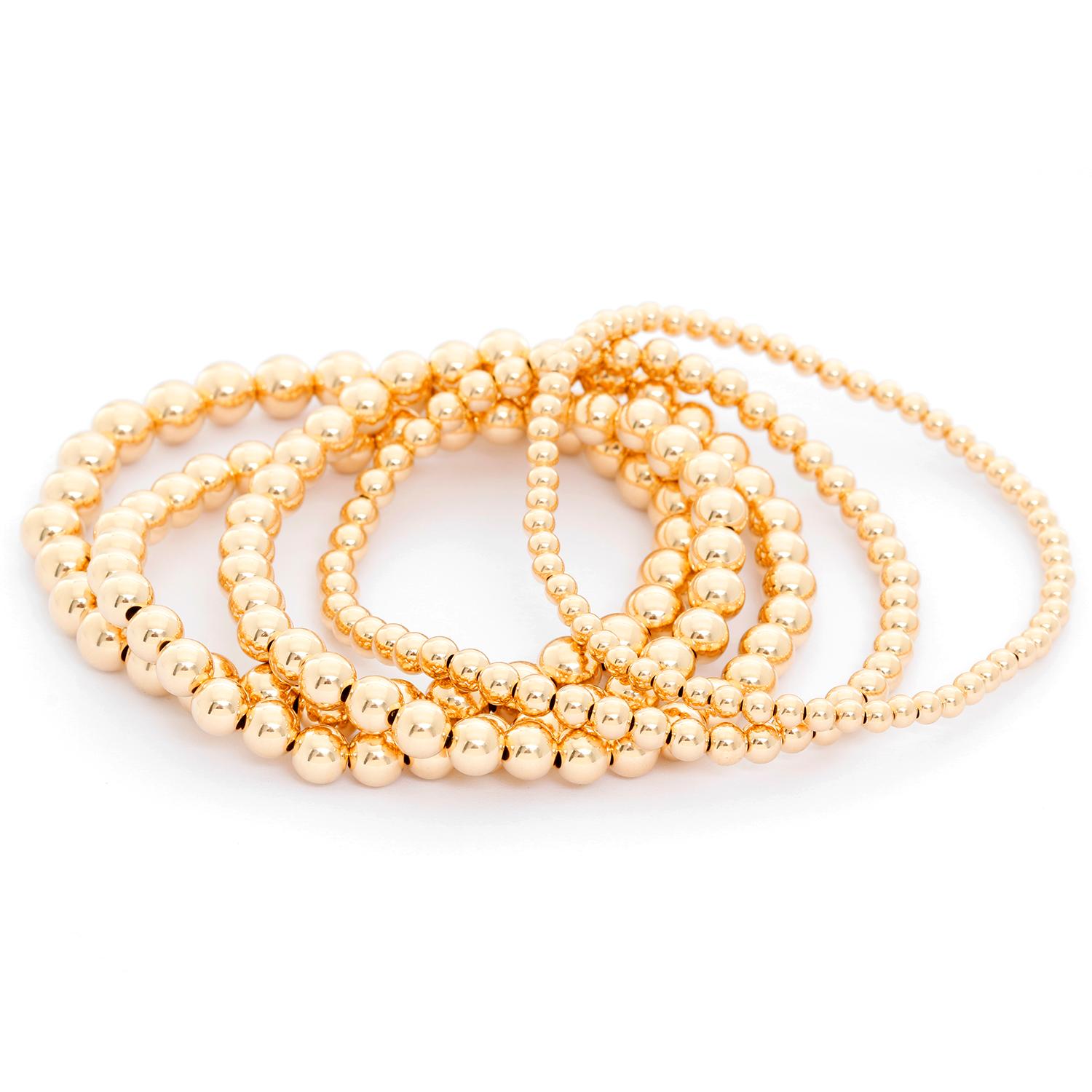 Gold Bead Ball Stretch Bracelets - Five stack-able bead bracelet. Pictured  one 3 mm, one 4 mm, two 5mm, one 6mm.  New with DeMesy pouch. Wearable all day and in the shower and they will still hold their luster and stretch.